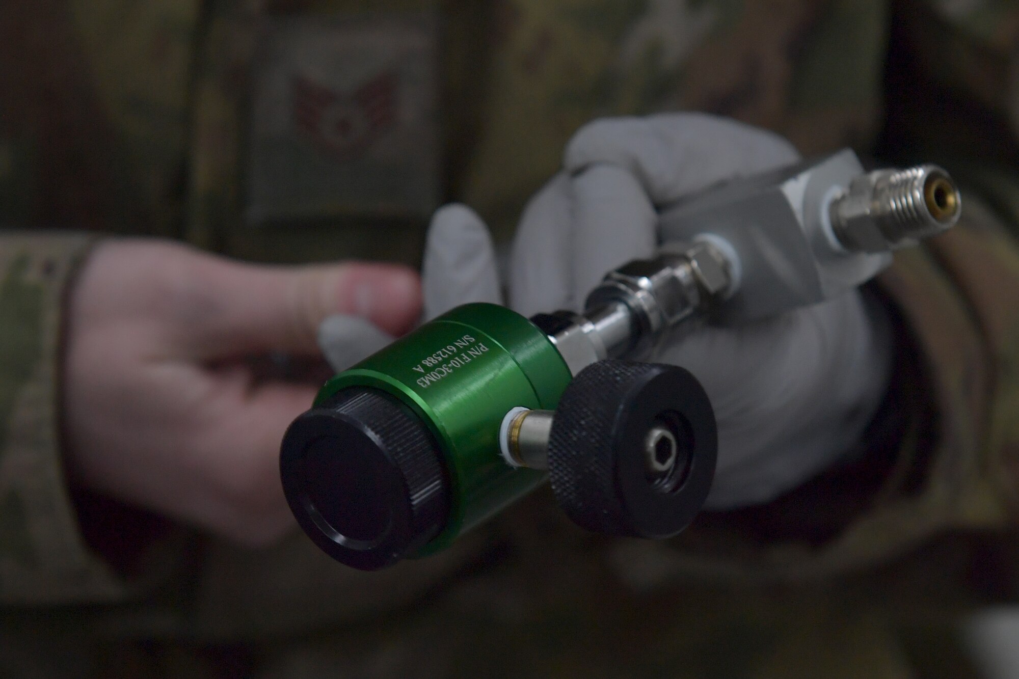 Close-up of hands holding an oxygen regulator.