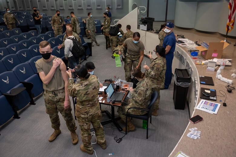 Airmen from the 60th Surgical Operations Squadron, 60th Inpatient Squadron, 60th Healthcare Operations Squadron and 60th Operational Medical Readiness Squadron are cleared through a three-step process to receive the COVID-19 vaccine Dec. 22, 2020, at Travis Air Force Base, California. The Airmen were among the first to receive the vaccine at David Grant U.S. Air Force Medical Center, the Air Force’s largest medical facility, which provides care to more than 276,000 Department of Defense and Veteran Affairs eligible beneficiaries. (U.S. Air Force photo by Senior Airman Cameron Otte)