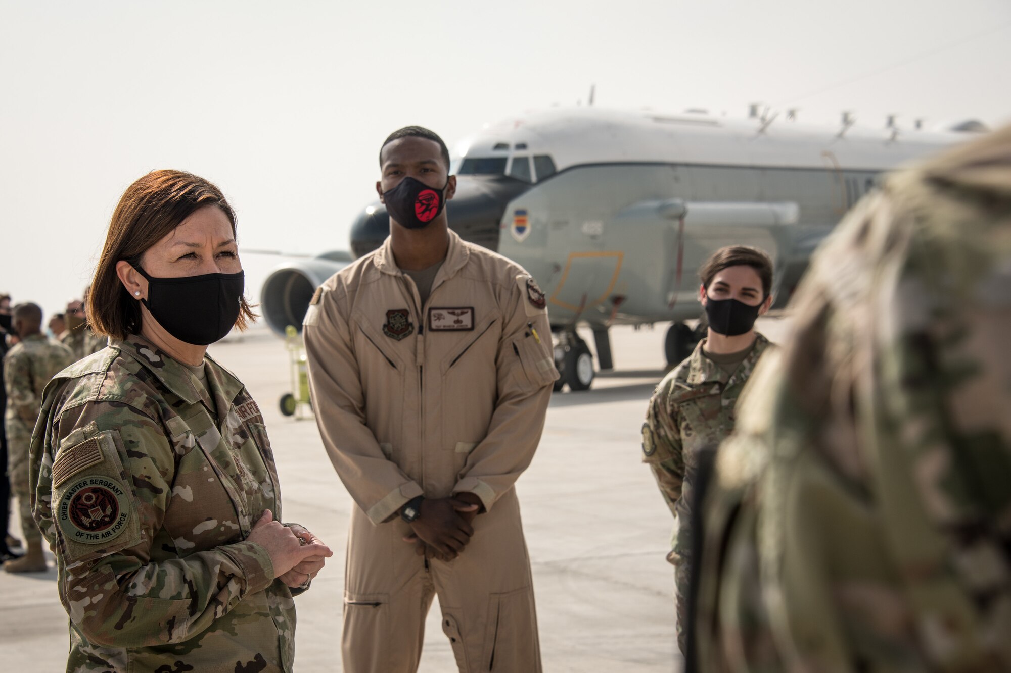 airmen speak to each other in front of an aircraft