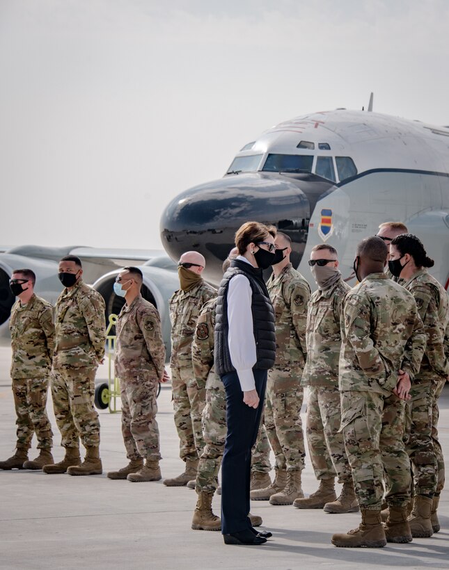 the secretary of the air force speaks with an airman in front of an aircraft