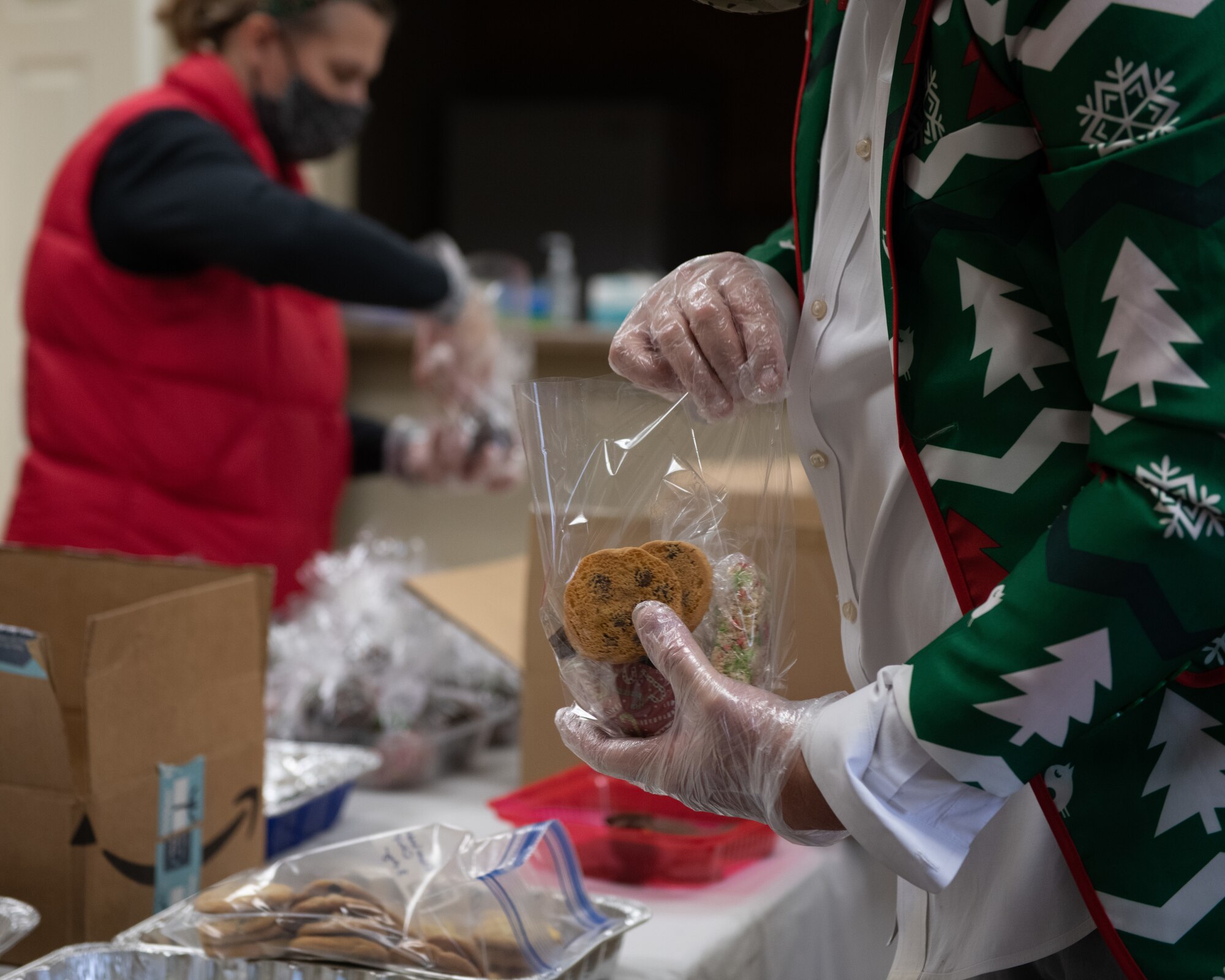 Eddy Mentzer places cookies into bags for Airmen Dec. 16, 2020, at the Hunt Housing Office on Maxwell Air Force Base. Volunteers repackaged donated cookies and other baked goods while wearing masks and gloves to reduce the risk of COVID-19 transmission.