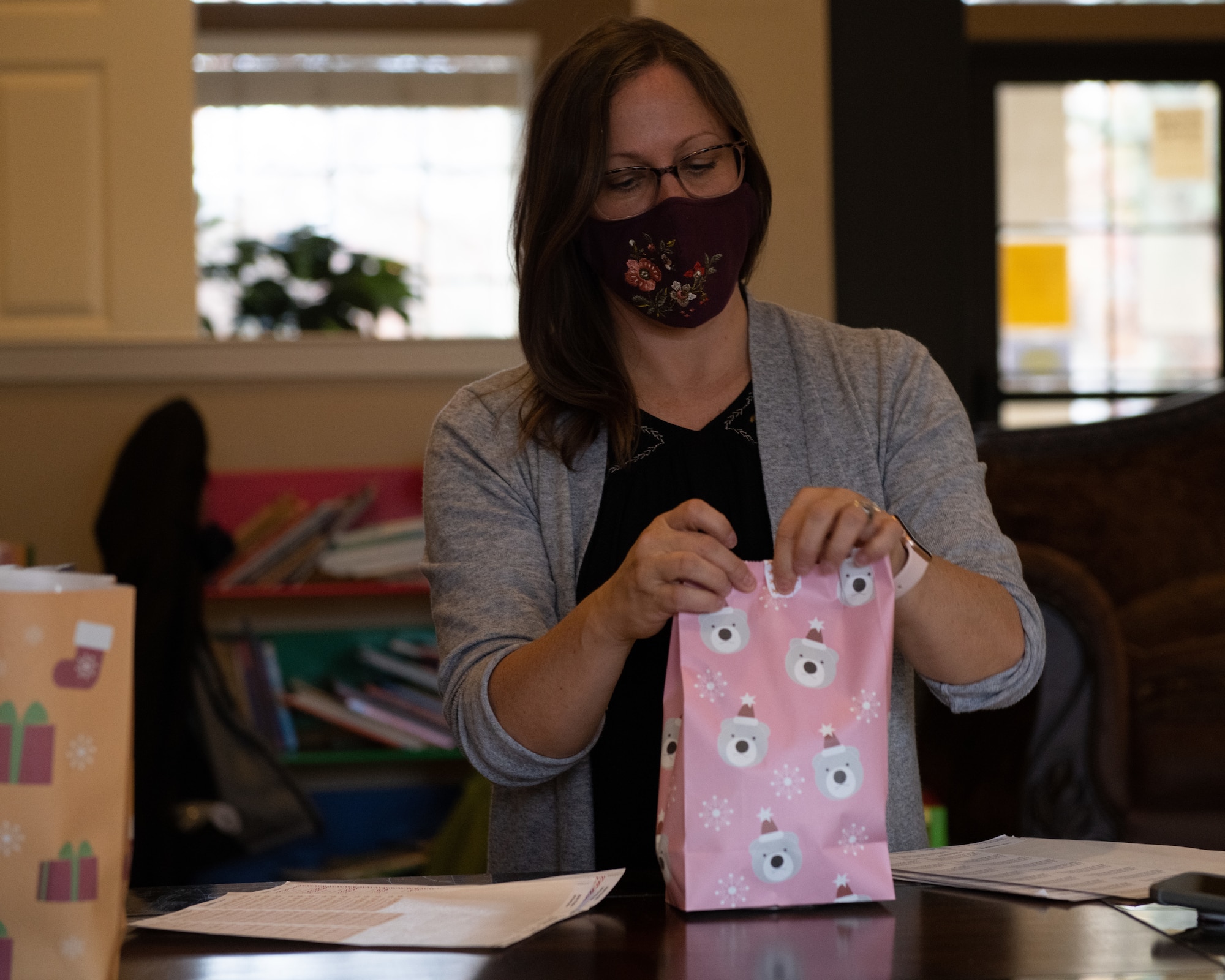 Kristen Morgan tapes a paper bag of baked goods closed Dec. 16, 2020, at the Hunt Housing Offices on Maxwell Air Force Base, Alabama. Volunteers wore masks while packaging cookies to reduce the risk of COVID-19 transmission.