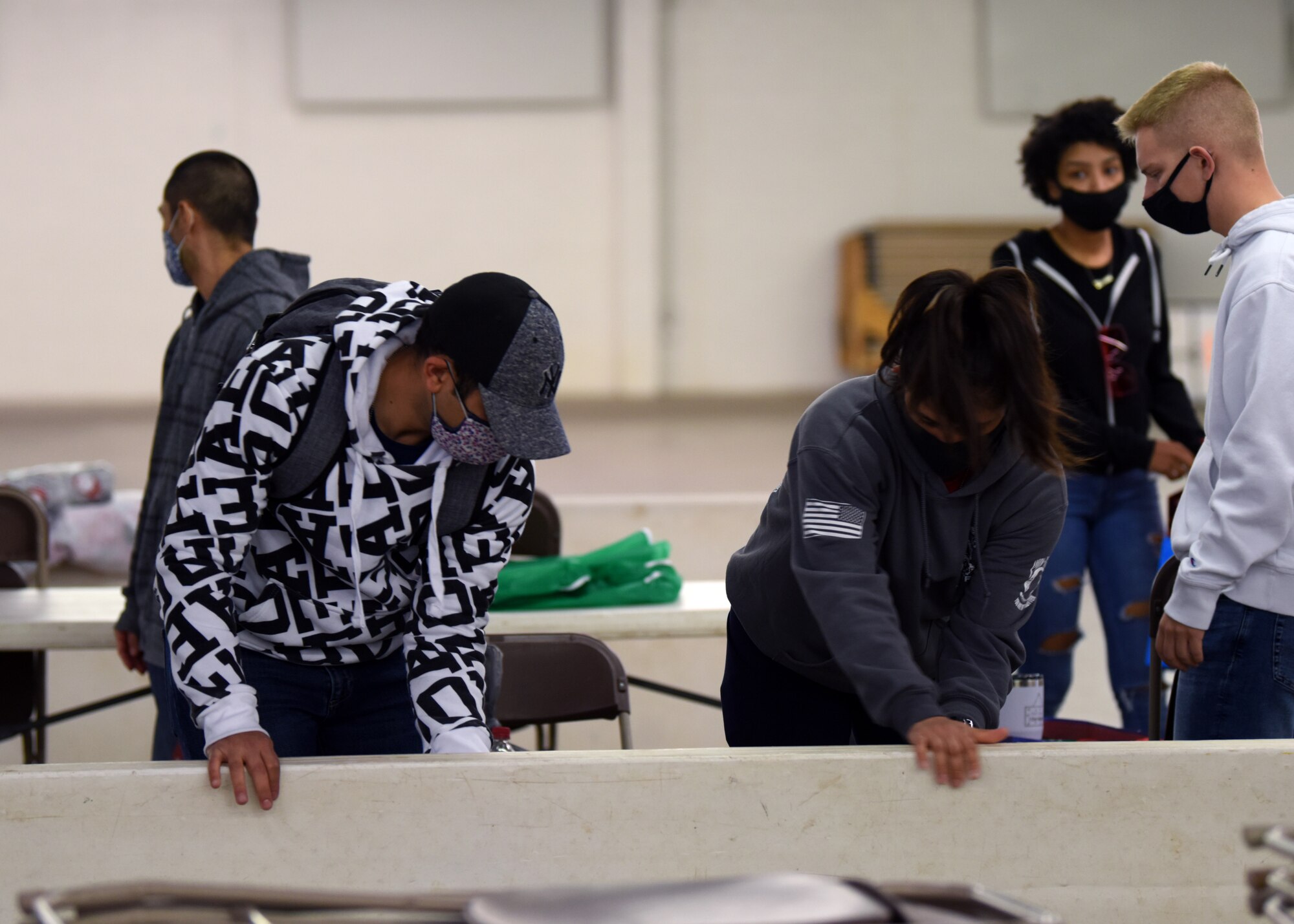 Airmen fold up a table after the Home Away From Home event in the First Financial Pavilion in San Angelo, Texas, Dec. 25, 2020. Members helped clean up after the event to show their thanks to the Elks Lodge for hosting them. (U.S. Air Force photo by Airman 1st Class Ethan Sherwood)