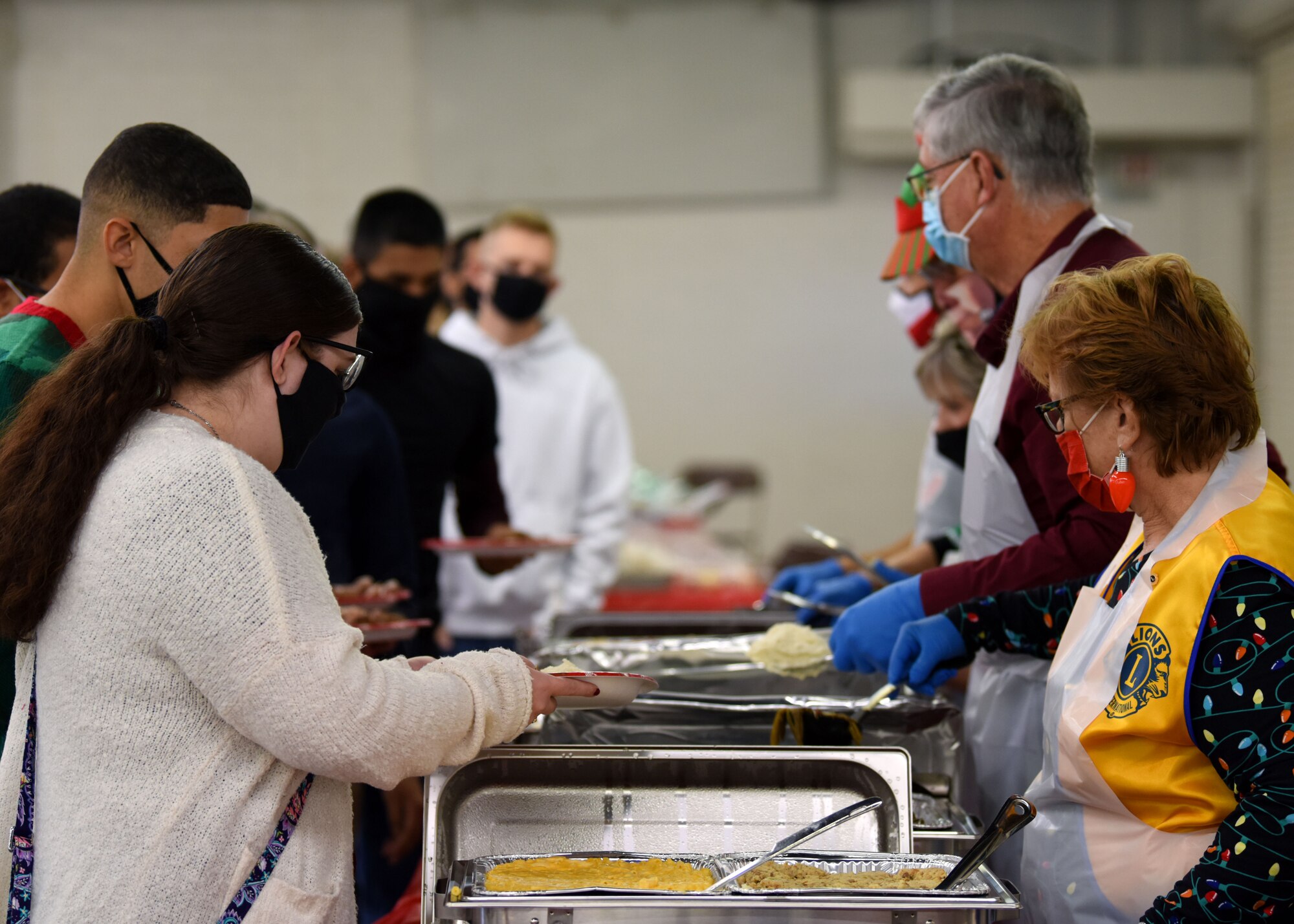 Volunteers serve food to military members at the Home Away From Home event in the First Financial Pavilion in San Angelo, Texas, Dec. 25, 2020. Volunteers prepared food for hours before the event and served military members, first responders, and delivered to those who couldn’t come to the event. (U.S. Air Force photo by Airman 1st Class Ethan Sherwood)