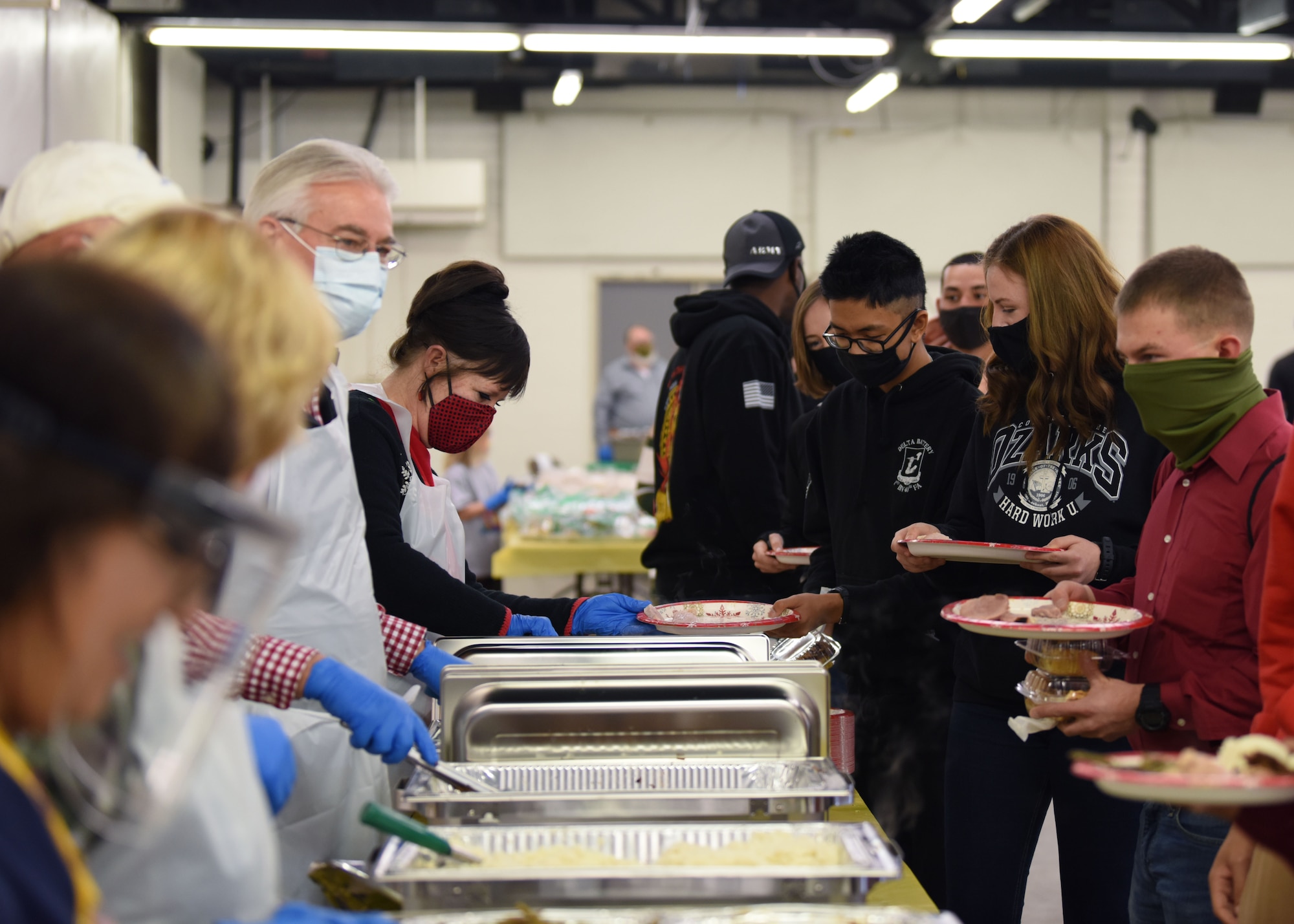 Volunteers serve food to military members at the Home Away From Home event in the First Financial Pavilion in San Angelo, Texas, Dec. 25, 2020. Drinks, desserts, and traditional holiday foods were served to over 60 individuals. (U.S. Air Force photo by Airman 1st Class Ethan Sherwood)
