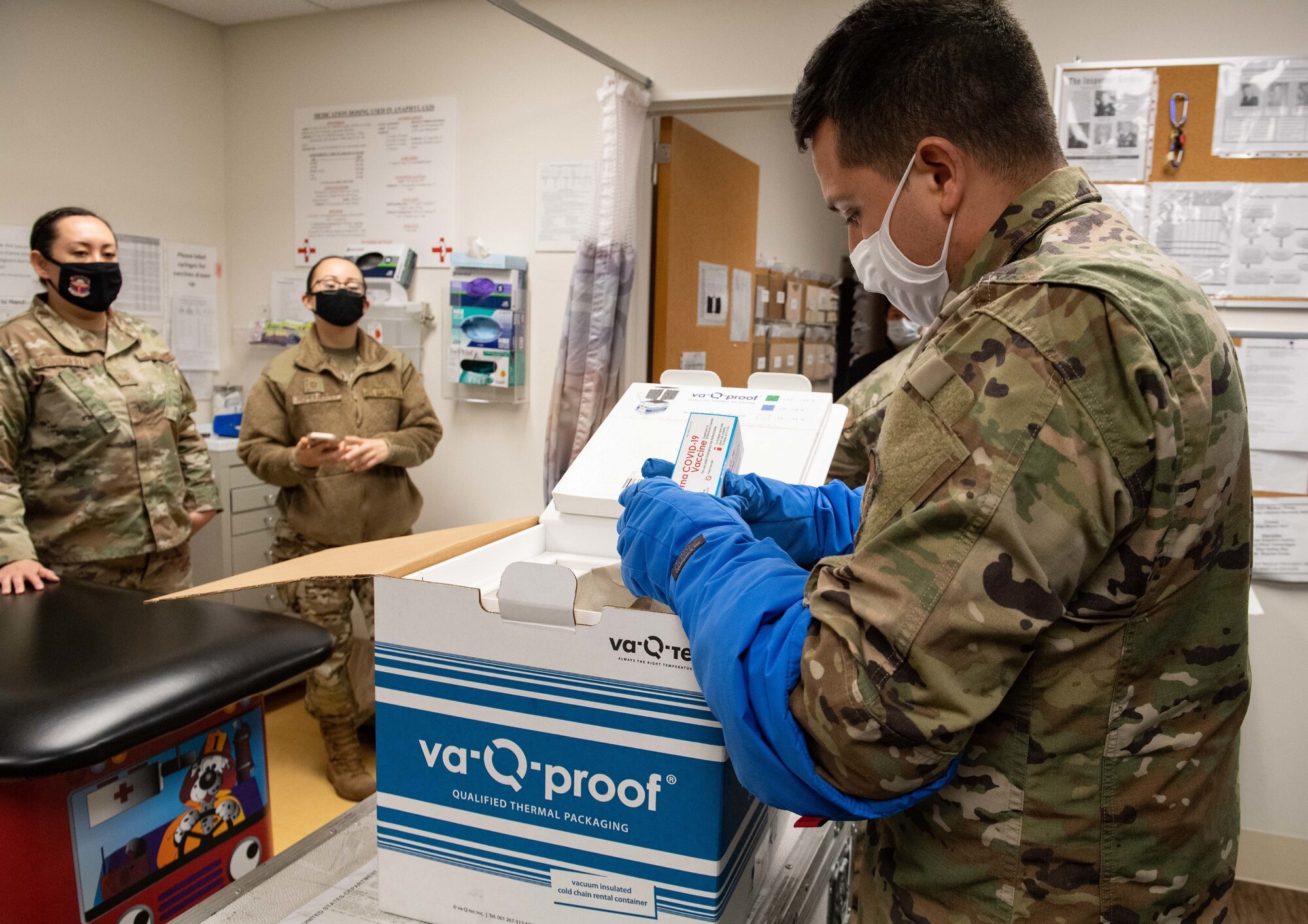 Staff Sgt. Daniel Monzon-Kazhe, 374th Medical Group non-commissioned officer in charge of contingency material, holds a box of Moderna COVID-19 vaccines