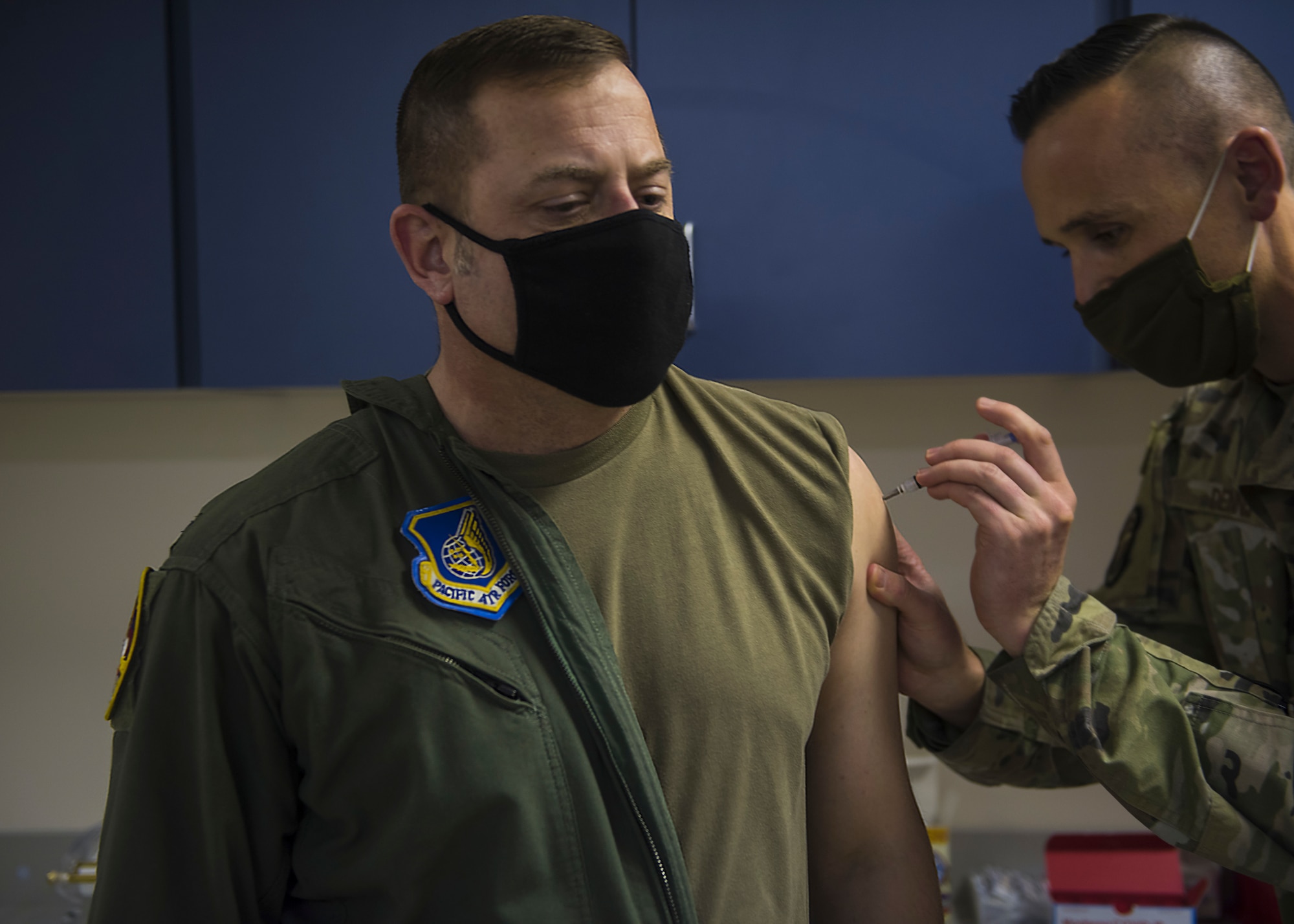 U.S. Air Force Staff Sgt. Gary Dennis, 35th Healthcare Operations Squadron NCO in charge of Allergy and Immunizations, gives Col. Jesse J. Friedel, 35th Fighter Wing commander, a dose of the COVID-19 vaccine at Misawa Air Base, Japan, Dec. 28, 2020. The Department of Defense began limited delivery of the COVID-19 vaccine to medical treatment facilities and other health care facilities for voluntary vaccination to mission essential personnel. (U.S. Air Force photo by Airman 1st Class Leon Redfern)