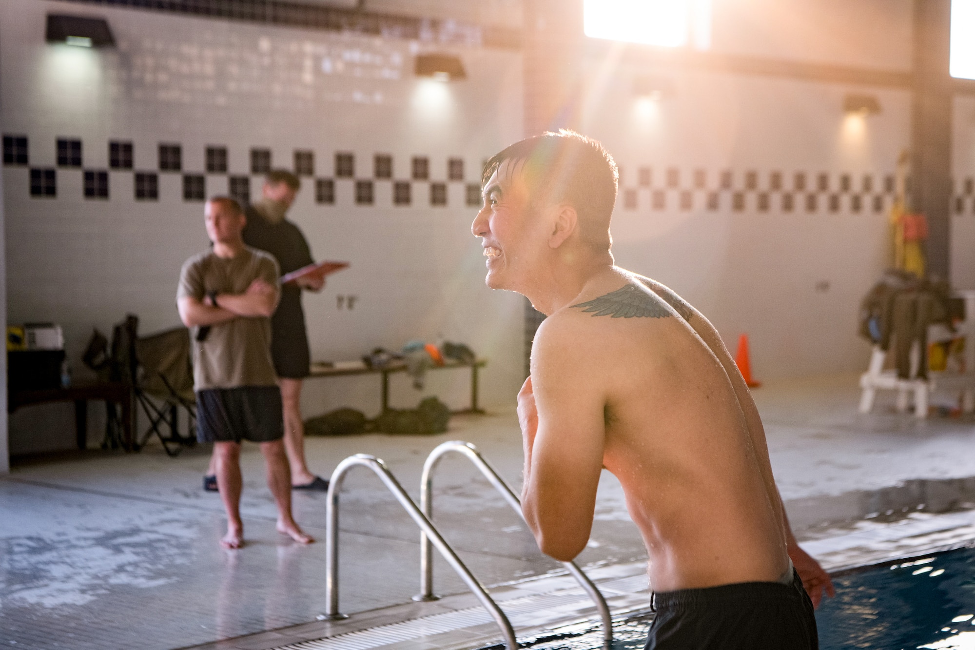 a man smiles in front of a pool