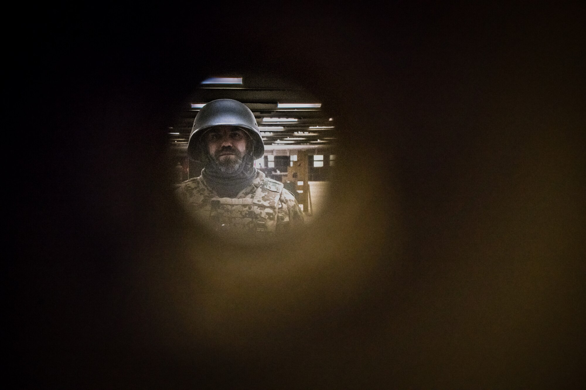 a man wearing a helmet peers through a small circle