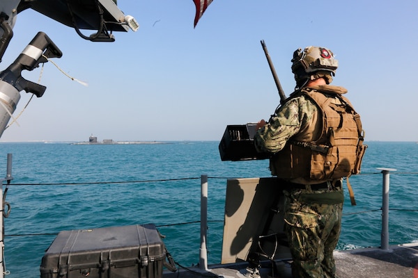 201223-A-HS292-1027 GULF OF BAHRAIN (Dec. 23, 2020) A Sailor assigned to Commander, Task Force (CTF) 56 stands watch aboard a Mark VI patrol boat while escorting the guided-missile submarine USS Georgia (SSGN 729) through the Gulf of Bahrain, inbound to a sustainment and logistics visit in Manama, Bahrain, Dec. 23. Georgia is deployed to the U.S. 5th Fleet area of operations in support of naval operations to ensure maritime stability and security in the Central Region, connecting the Mediterranean and Pacific through the Western Indian Ocean and three critical chokepoints to the free flow of global commerce.