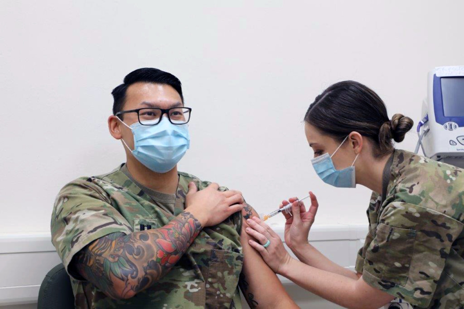 U.S. Army Capt. Joey Nguyen (left), a nurse assigned to 2nd Cavalry Regiment, receives the Moderna COVID-19 vaccine from U.S. Army Capt. Breslin Gillis (right) at the Soldier Readiness Processing Center, Rose Barracks, Vilseck, Germany, Dec. 28, 2020. Nguyen is the first to receive the COVID-19 vaccine in the Vilseck military community.