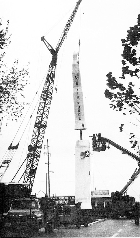 A crane places a large missile.