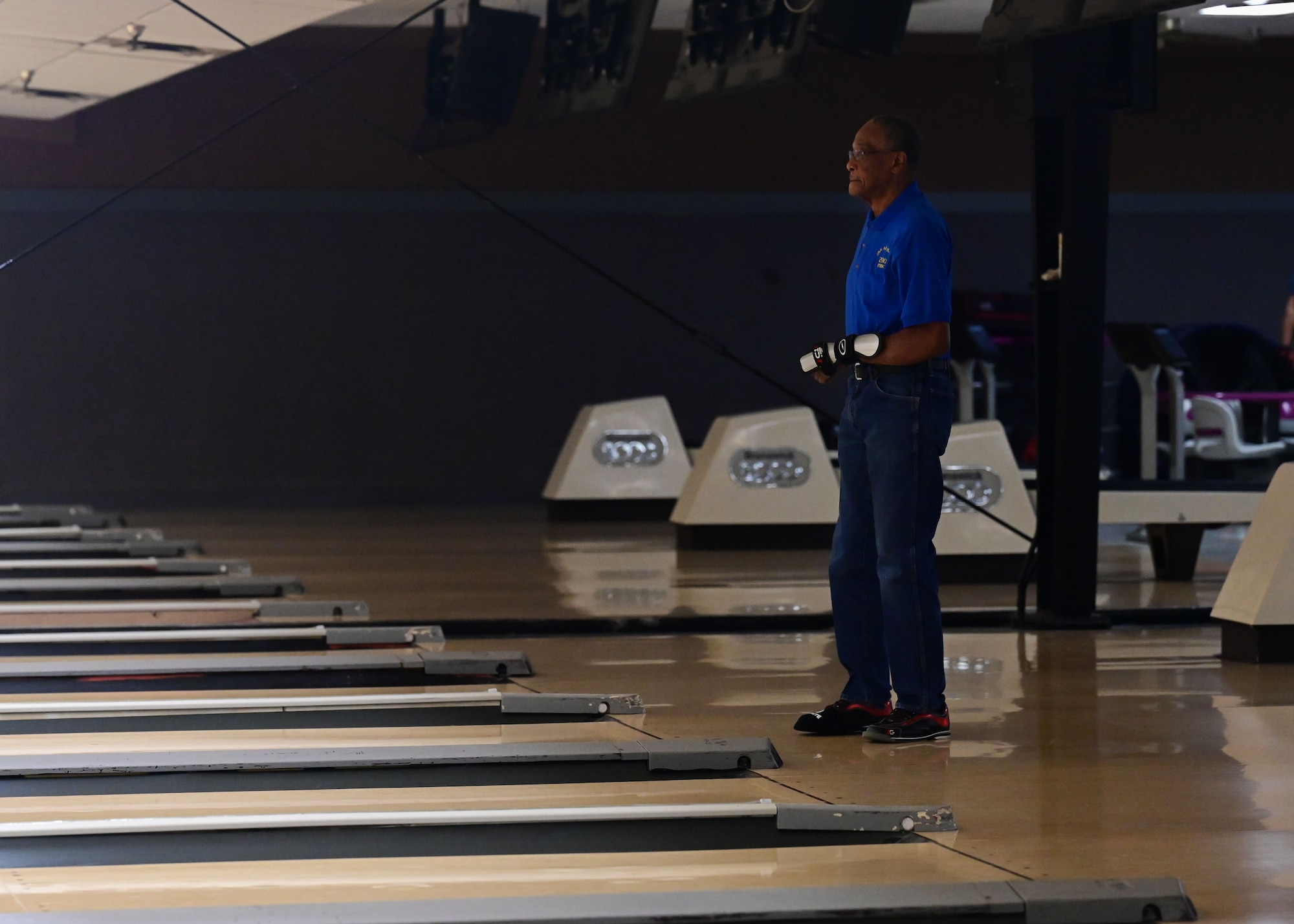 A man looks down the lane of a bowling alley.
