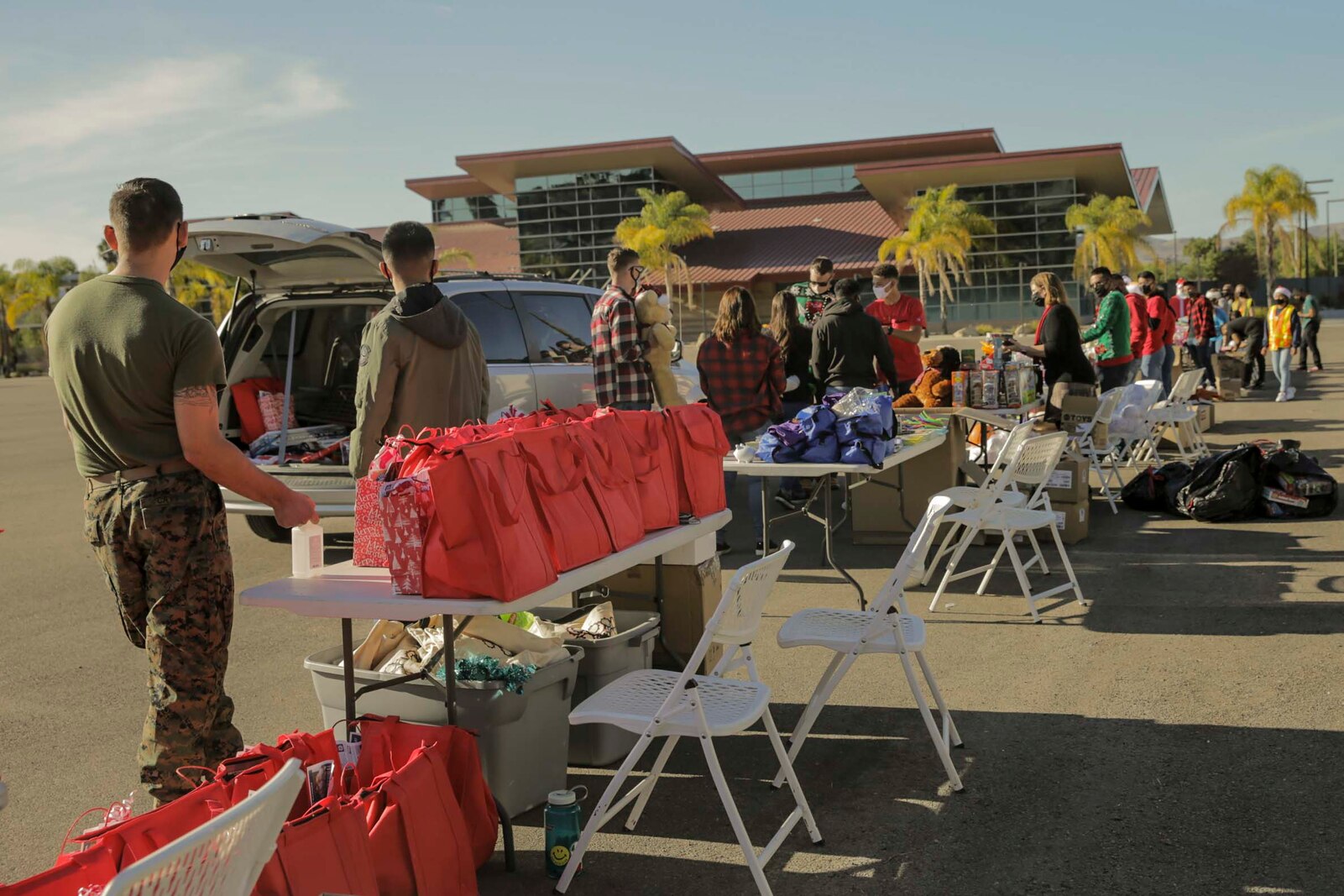U.S. Service Members with 1st Supply Battalion, gifts toys to families during a drive in holiday gift event.