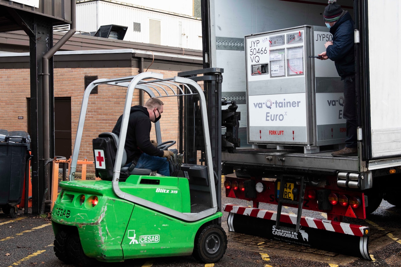A man in a forklift approaches a container.