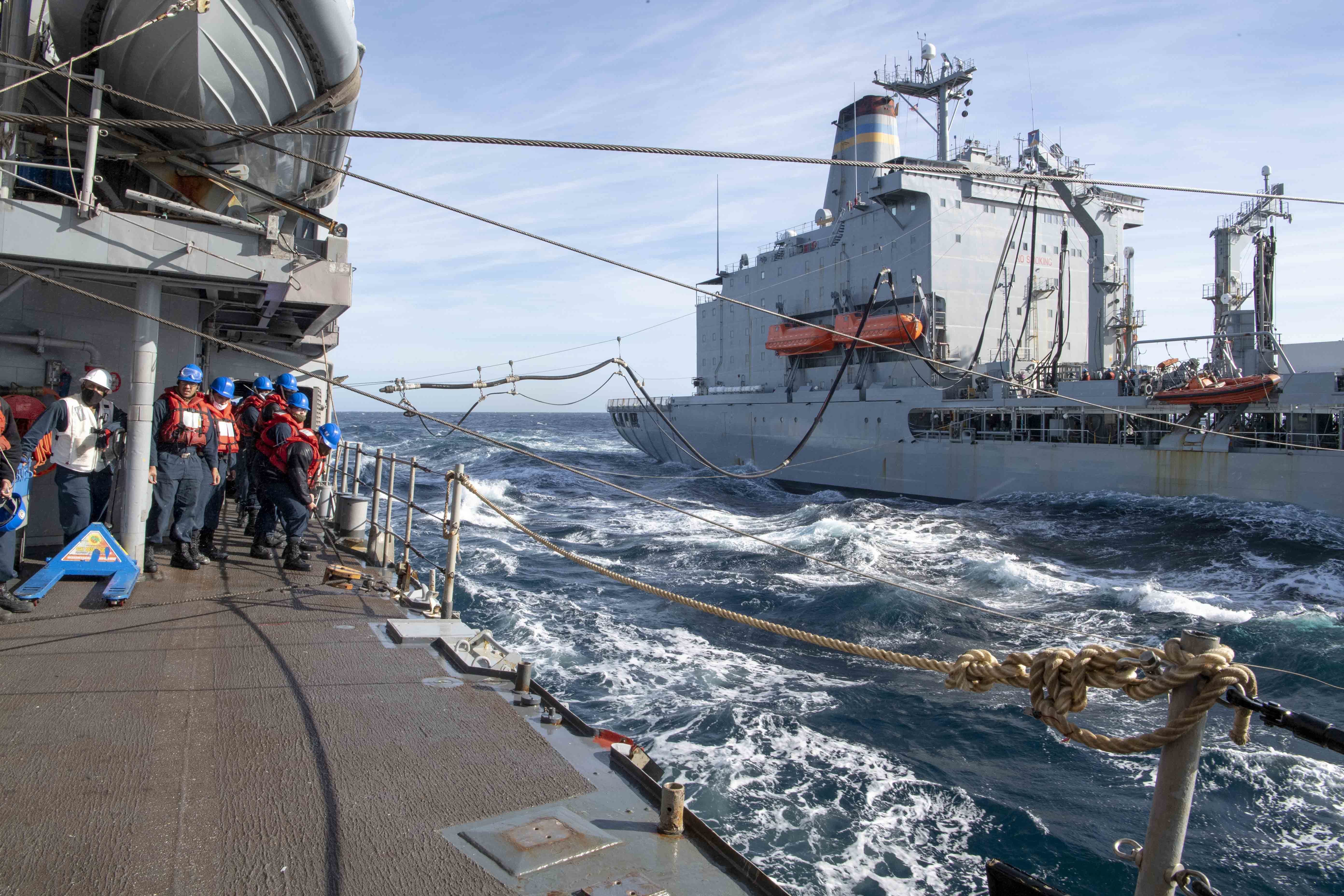 The Military Sealift Command fleet replenishment oiler USNS Guadalupe (T-AO 200) sends a fuel probe to the Ticonderoga-class guided-missile cruiser USS Bunker Hill (CG 52) during a fueling at sea Dec. 14, 2020.