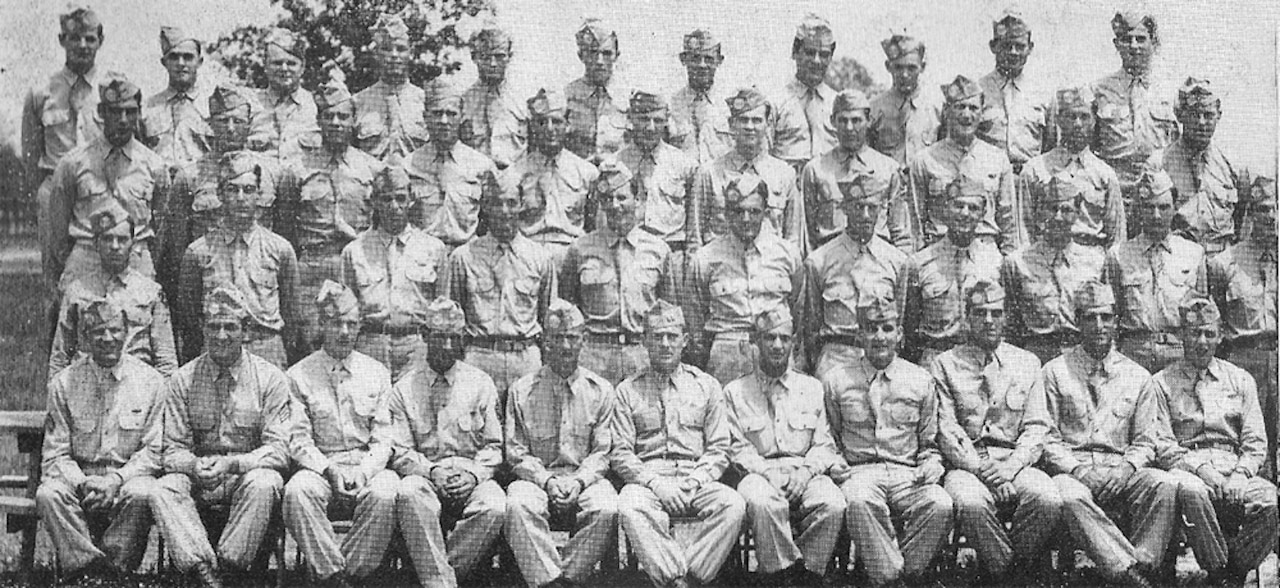 Four rows of soldiers line up for a photo, one behind the other.