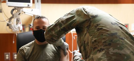 Sgt. Parmer Smith administers one of the first COVID-19 vaccines to Staff Sgt. David Nagy at Brian D. Allgood Army Community Hospital.