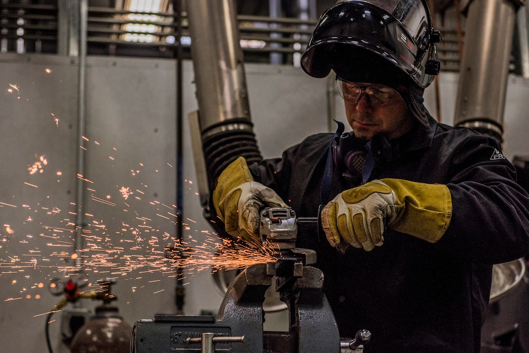 A National Guardsman welds a project as sparks fly.