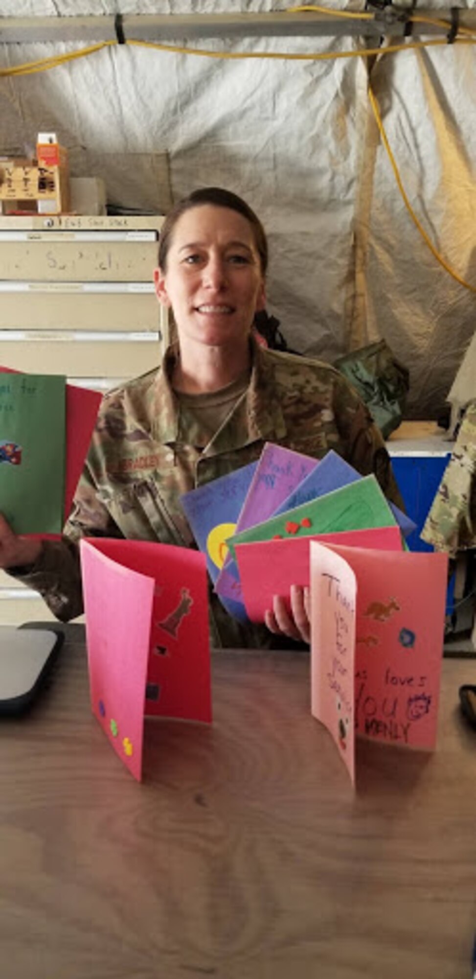 Senior Airman Jayme Bradley, an electrical and environmental specialist for the 175th Maintenance Squadron, Maryland National Guard, poses with cards sent to her from her home church April 8, 2019 during her deployment to Kandahar, Afghanistan.