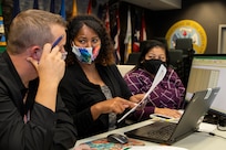 From left to right, Scott Ferge, Eddra Peoples and Joyce Dean, U.S. Army Financial Management Command Accounting and Oversight Operations systems accountants, discuss the best way to deal with transaction to ensure it hits the Army’s financial statements appropriately during fiscal year 2020 closeout at the Maj. Gen. Emmett J. Bean Federal Center in Indianapolis Sept. 30, 2020. USAFMCOM supported year-end closeout operations across the Army from a newly setup command center with special precautions in place to protect employees during the Coronavirus (COVID-19) pandemic. (U.S. Army photo by Mark R. W. Orders-Woempner)