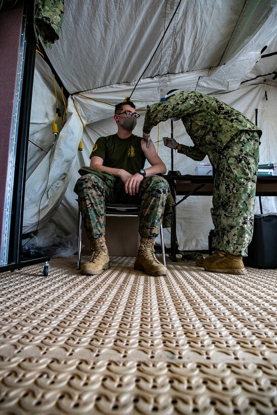 U.S. Marines and sailors with III Marine Expeditionary Force receive COVID-19 vaccines on Camp Foster, Okinawa, Japan, Dec. 29, 2020. Each individual had the option to receive or decline the vaccine. Vaccination distribution prioritization focuses on those providing direct medical care, maintaining essential national security and installation functions, deploying forces, and those at the highest risk for developing severe illness from COVID-19. The vaccine was administered to III MEF medical and installation personnel, which were identified as the first phase of the DOD COVID-19 vaccine plan, to remain a lethal and ready expeditionary fighting force. (U.S. Marine Corps photo by Lance Cpl. Natalie Greenwood)