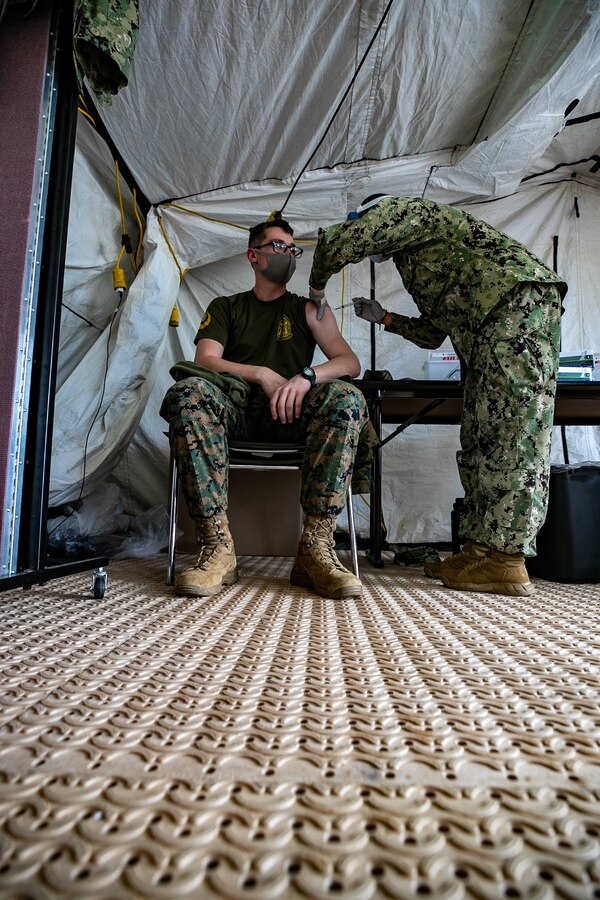 U.S. Marines and sailors with III Marine Expeditionary Force receive COVID-19 vaccines on Camp Foster, Okinawa, Japan, Dec. 29, 2020. Each individual had the option to receive or decline the vaccine. Vaccination distribution prioritization focuses on those providing direct medical care, maintaining essential national security and installation functions, deploying forces, and those at the highest risk for developing severe illness from COVID-19. The vaccine was administered to III MEF medical and installation personnel, which were identified as the first phase of the DOD COVID-19 vaccine plan, to remain a lethal and ready expeditionary fighting force. (U.S. Marine Corps photo by Lance Cpl. Natalie Greenwood)