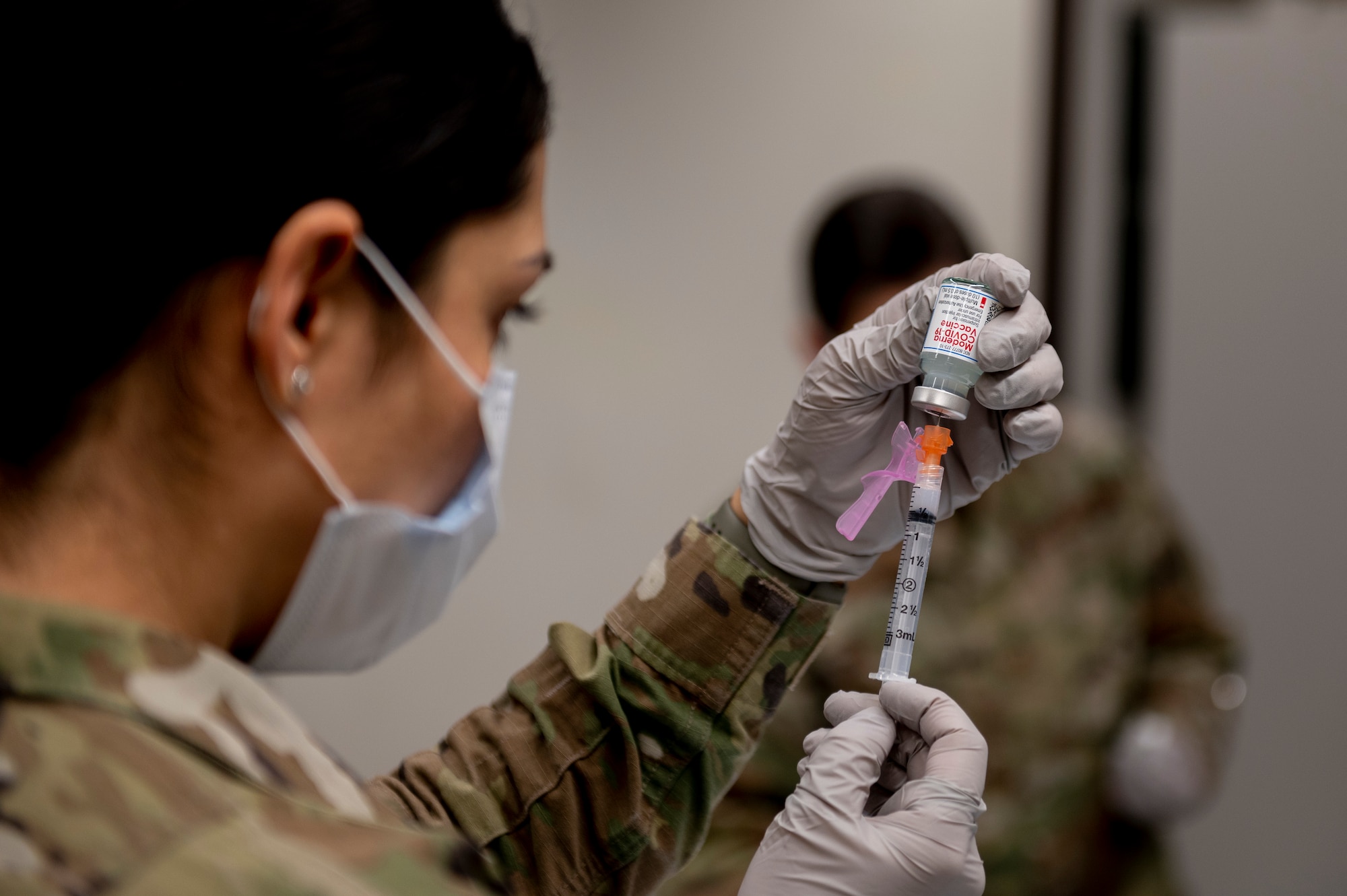 a military member prepares a vaccine