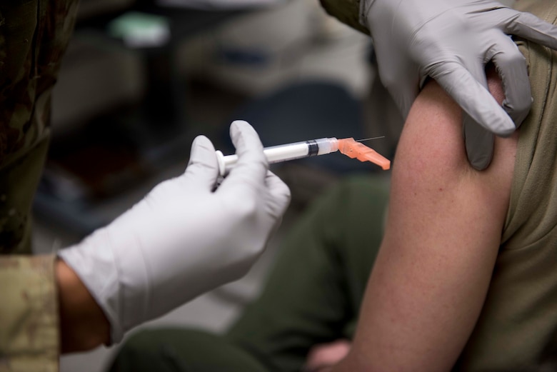 a photo of a woman giving another woman a vaccine shot