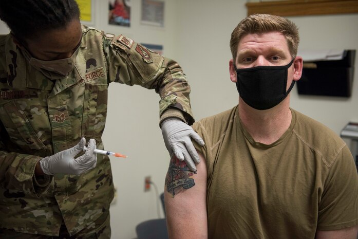 woman giving man a vaccine shot