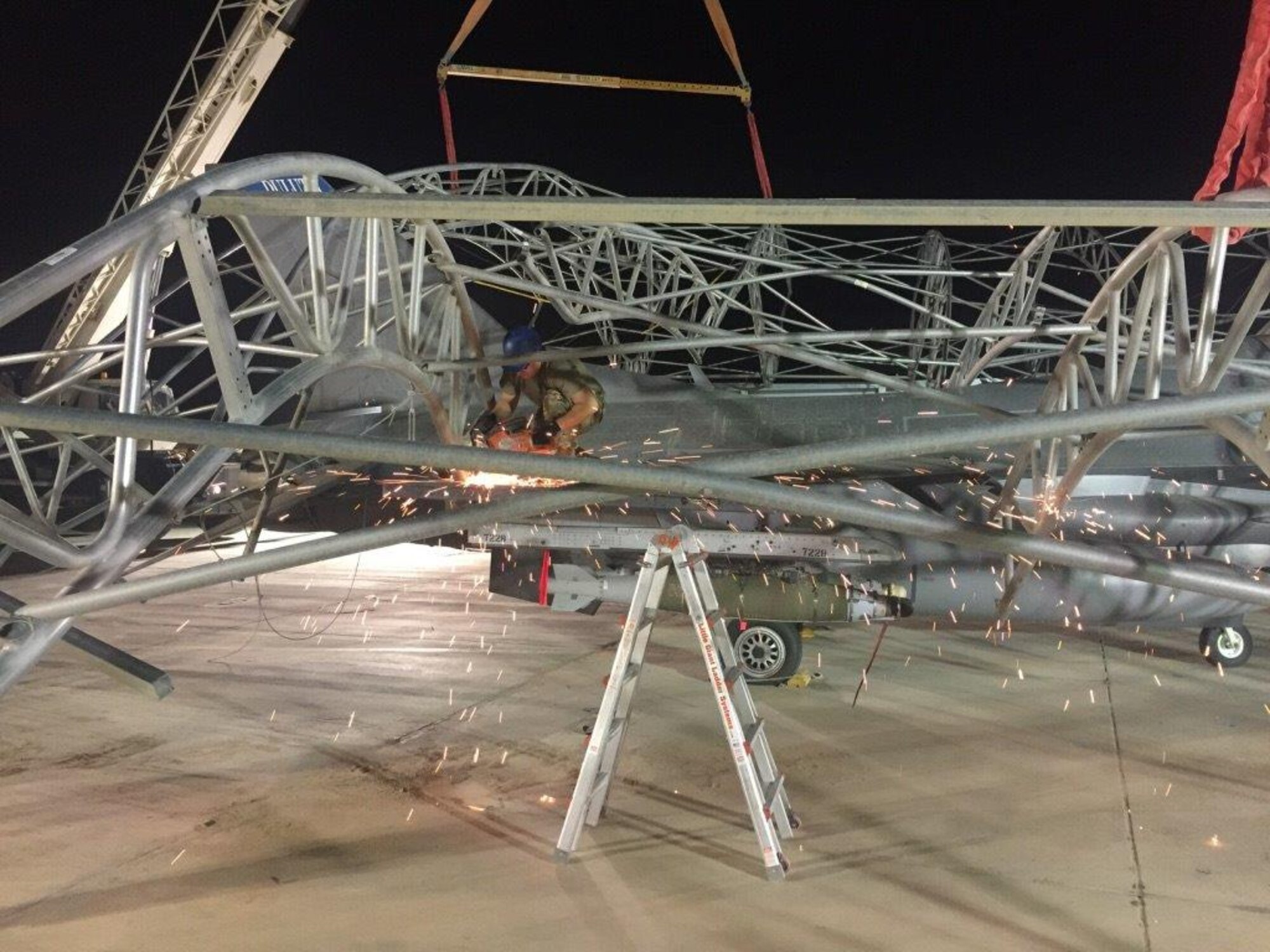 Civil Engineers and aircraft maintenance personnel untangle and remove sunshades after they collapsed on F-16 Fighting Falcons during a storm that caused 91-mile per hour winds at the 407th Air Expeditionary Group in 2018.