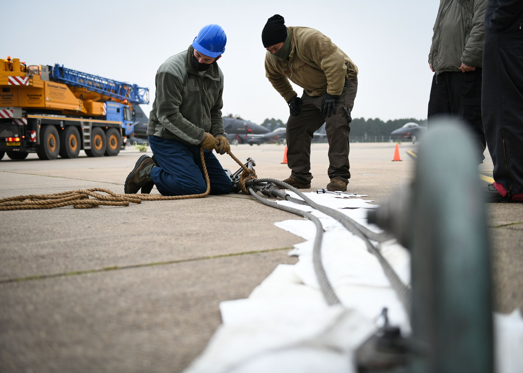 Airmen assigned to the 48th Equipment Maintenance Squadron repair and reclamation sections prepare a wire cable sling for a simulated crash and recovery aircraft lift at Royal Air Force Lakenheath, England, Dec. 29, 2020. The repair and reclamation section’s most important responsibility for the 48th Fighter Wing is the in-flight, ground emergency, and the Crash Damaged Disabled Aircraft Recovery program. This program requires members to be ready at a moment’s notice to respond to any CDDAR event anywhere and anytime. (U.S. Air Force photo by Senior Airman Madeline Herzog)