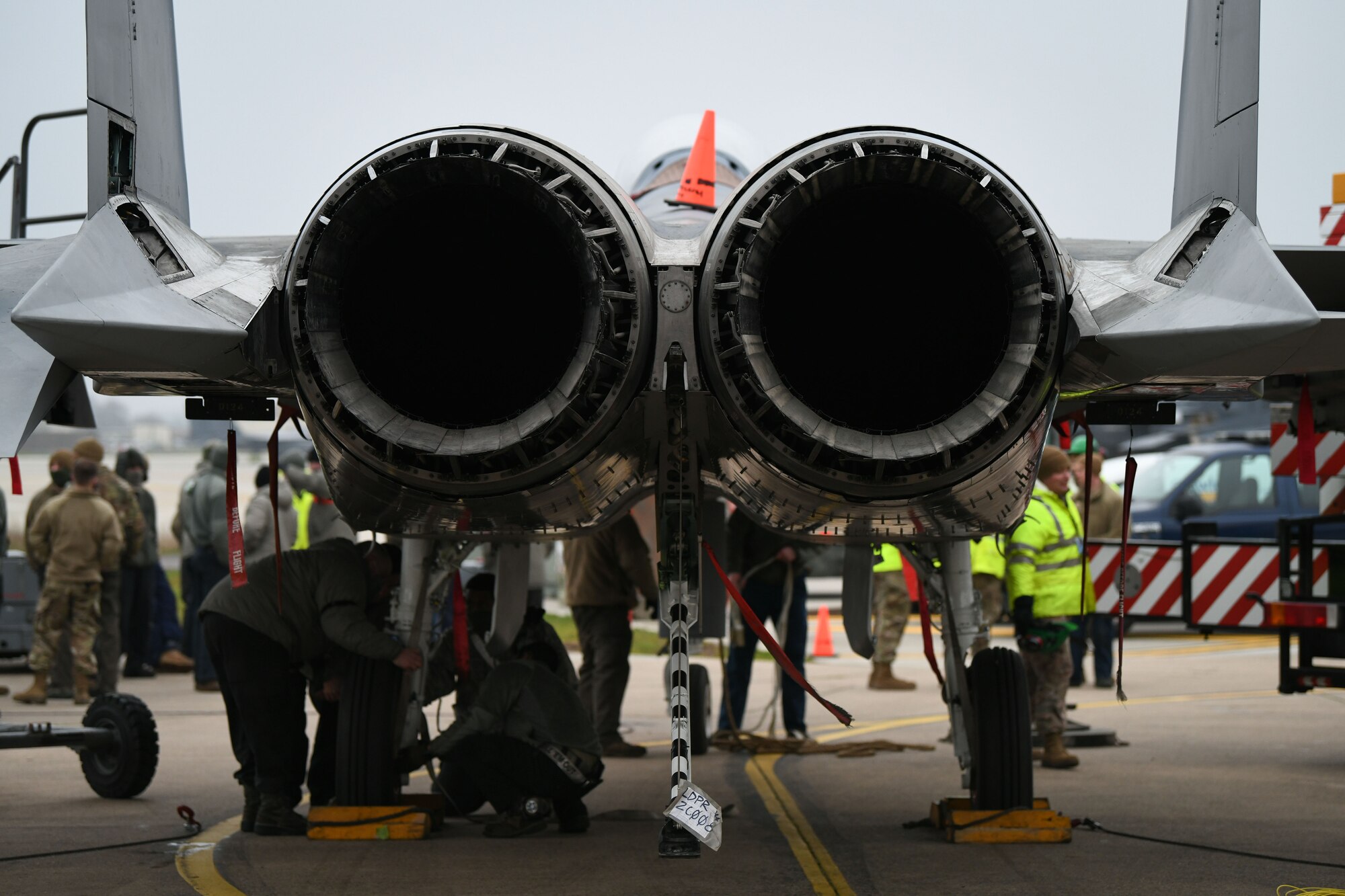 Airmen assigned to the 48th Equipment Maintenance Squadron repair and reclamation sections attach a turfer to the underside of an F-15B in order to keep it stable when the aircraft is lifted off the ground during a simulated crash and recovery lift at Royal Air Force Lakenheath, England, Dec. 29, 2020. One of the repair and reclamation section’s main responsibilities is the Crash Damaged Disabled Aircraft Recovery program, which requires members to be ready at a moment’s notice to respond to any CDDAR event anywhere anytime. (U.S. Air Force photo by Senior Airman Madeline Herzog)