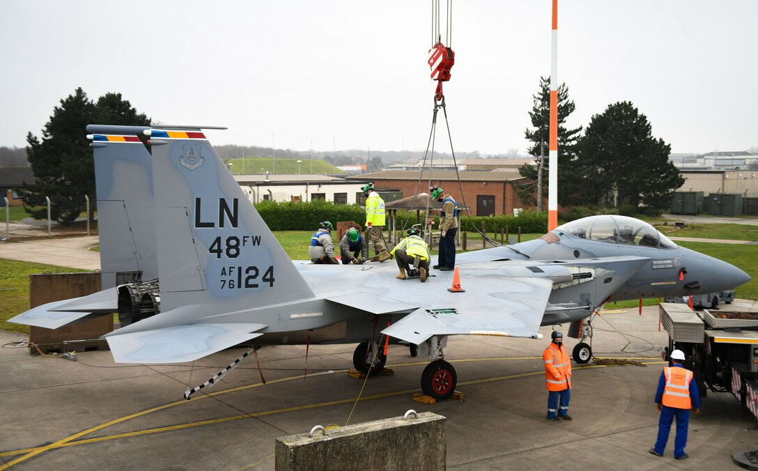 Airmen assigned to the 48th Equipment Maintenance Squadron repair and reclamation sections prepare an F-15B for a crane lift as part of the Crash Damaged Disabled Aircraft Recovery program at Royal Air Force Lakenheath, England, Dec. 29, 2020. This was the first crane lift at RAFL in 10 years and provided the recertification for the CDDAR program to six team chiefs and eight CDDAR members to ensure the wing is ready at a moment’s notice. (U.S. Air Force photo by Senior Airman Madeline Herzog)