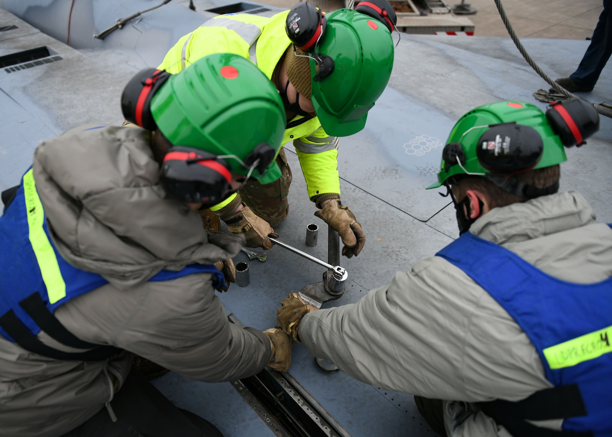 Airmen assigned to the 48th Equipment Maintenance Squadron repair and reclamation sections work together to secure an aircraft sling to an F-15B at Royal Air Force Lakenheath, England, Dec. 29, 2020. Attaching the sling was part of a simulated crash and recovery exercise for the Crash Damaged Disabled Aircraft Recovery program. This program requires members to be ready at a moment’s notice to respond to any CDDAR event anywhere and anytime. (U.S. Air Force photo by Senior Airman Madeline Herzog)
