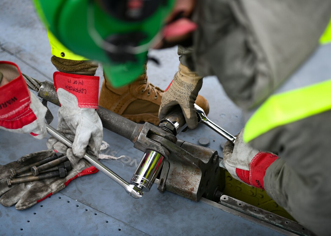 Airmen assigned to the 48th Equipment Maintenance Squadron repair and reclamation sections tighten a bolt to a wire cable sling during a simulated crash and recovery aircraft lift at Royal Air Force Lakenheath, England, Dec. 29, 2020. This was the first crane lift at RAFL in 10 years and provided the recertification for the CDDAR program to six team chiefs and eight CDDAR members to ensure the wing is ready at a moment’s notice. (U.S. Air Force photo by Senior Airman Madeline Herzog)
