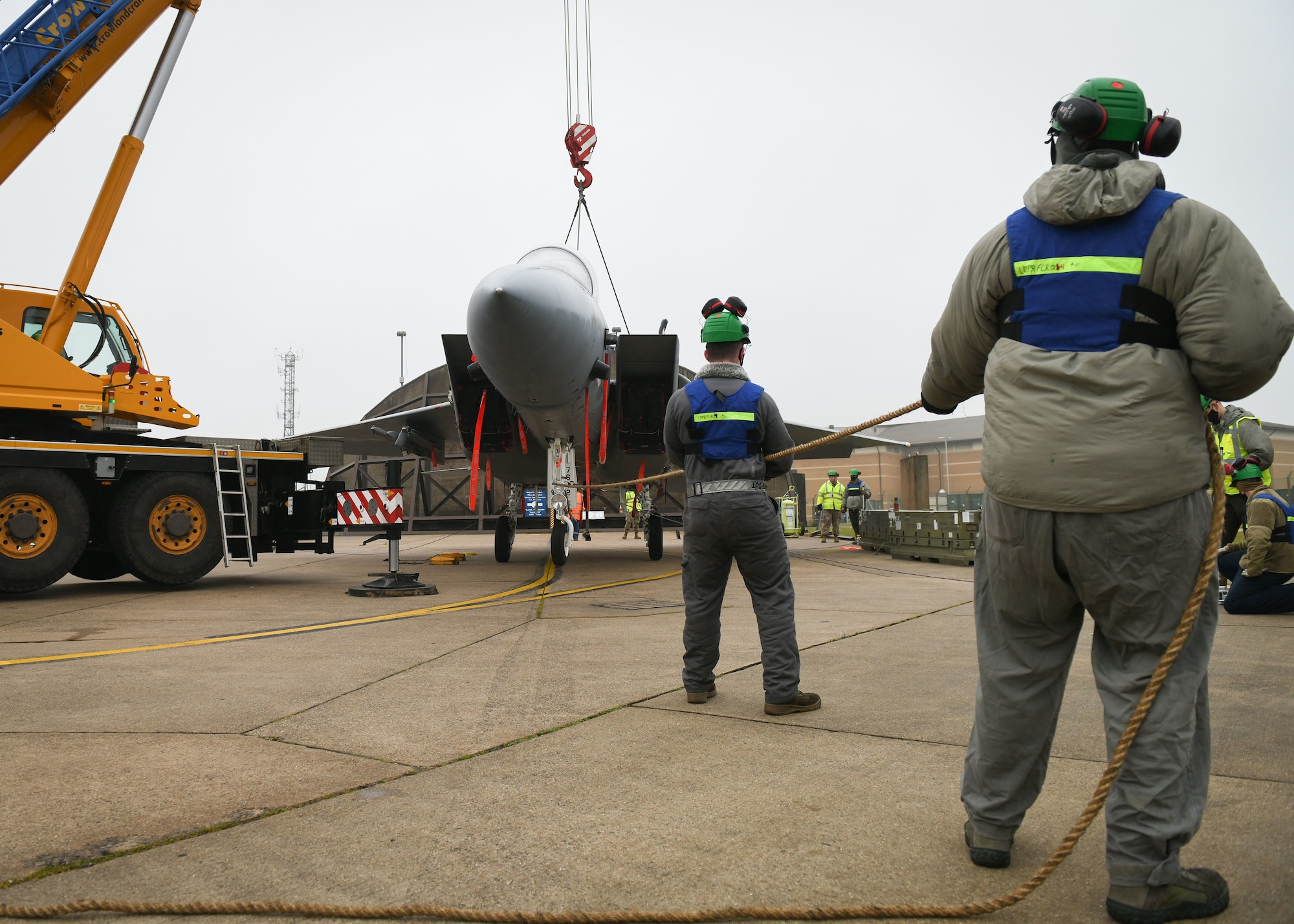 Airmen assigned to the 48th Equipment Maintenance Squadron repair and reclamation sections provide stabilization using a turfer during a simulated crash and recovery aircraft lift at Royal Air Force Lakenheath, England, Dec. 29, 2020. The Airmen are members of the Crash Damaged Disabled Aircraft Recovery program and attained recertification after completing the training successfully. (U.S. Air Force photo by Senior Airman Madeline Herzog)