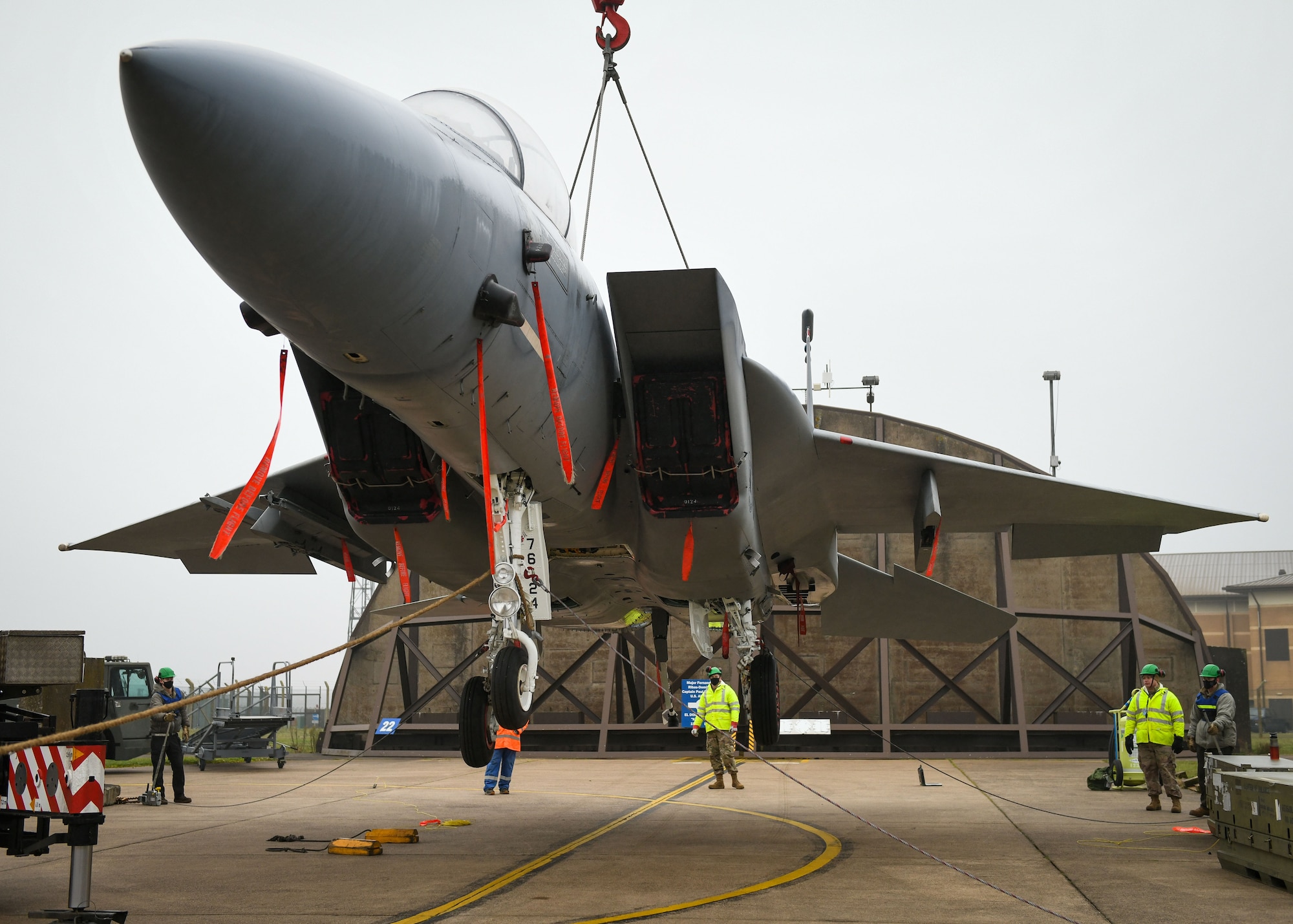 An F-15B is lifted by a crane during a simulated crash and recovery training at Royal Air Force Lakenheath, England, Dec. 29, 2020. This was the first crane lift at RAFL in 10 years and provided the recertification for the Crash Damaged Disabled Aircraft Recovery program to six team chiefs and eight CDDAR members to ensure the wing is ready at a moment’s notice. (U.S. Air Force photo by Senior Airman Madeline Herzog)