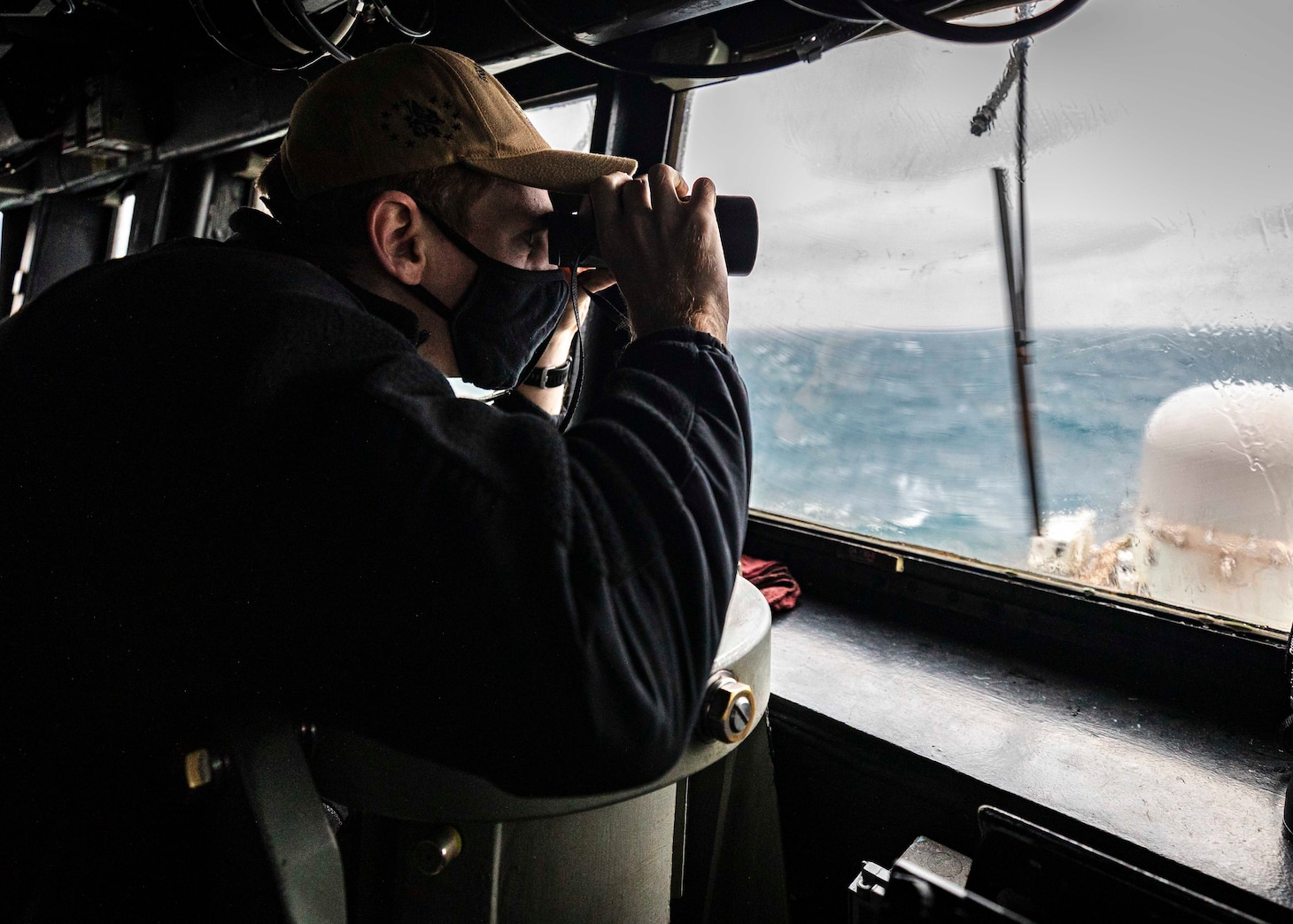 SOUTH CHINA SEA (Dec. 30, 2020) Ensign Grayson Sigler, from Corpus Christi, Texas, scans the horizon while standing watch in the pilot house as guided-missile destroyer USS John S. McCain (DDG 56) conducts routine underway operations in support of stability and security for a free and open Indo-Pacific. Sea control is foundational for all other naval missions that support the Joint Force, including power projection.