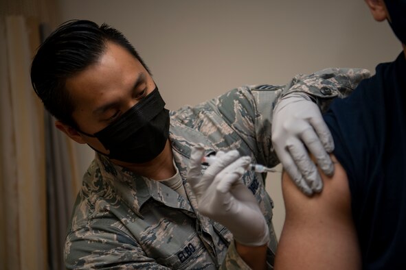 Staff Sgt. Michael Elbo, 509th Healthcare Operations Squadron NCO in charge of immunizations, administers a COVID-19 vaccine at Whiteman Air Force Base, Missouri, Dec. 30, 2020. The Whiteman AFB COVID-19 vaccine distribution and administration plan will implement a phased, standardized and coordinated strategy for prioritizing, distributing, and administering COVID-19 vaccines to installation personnel. (U.S. Air Force photo by Staff Sgt. Dylan Nuckolls)