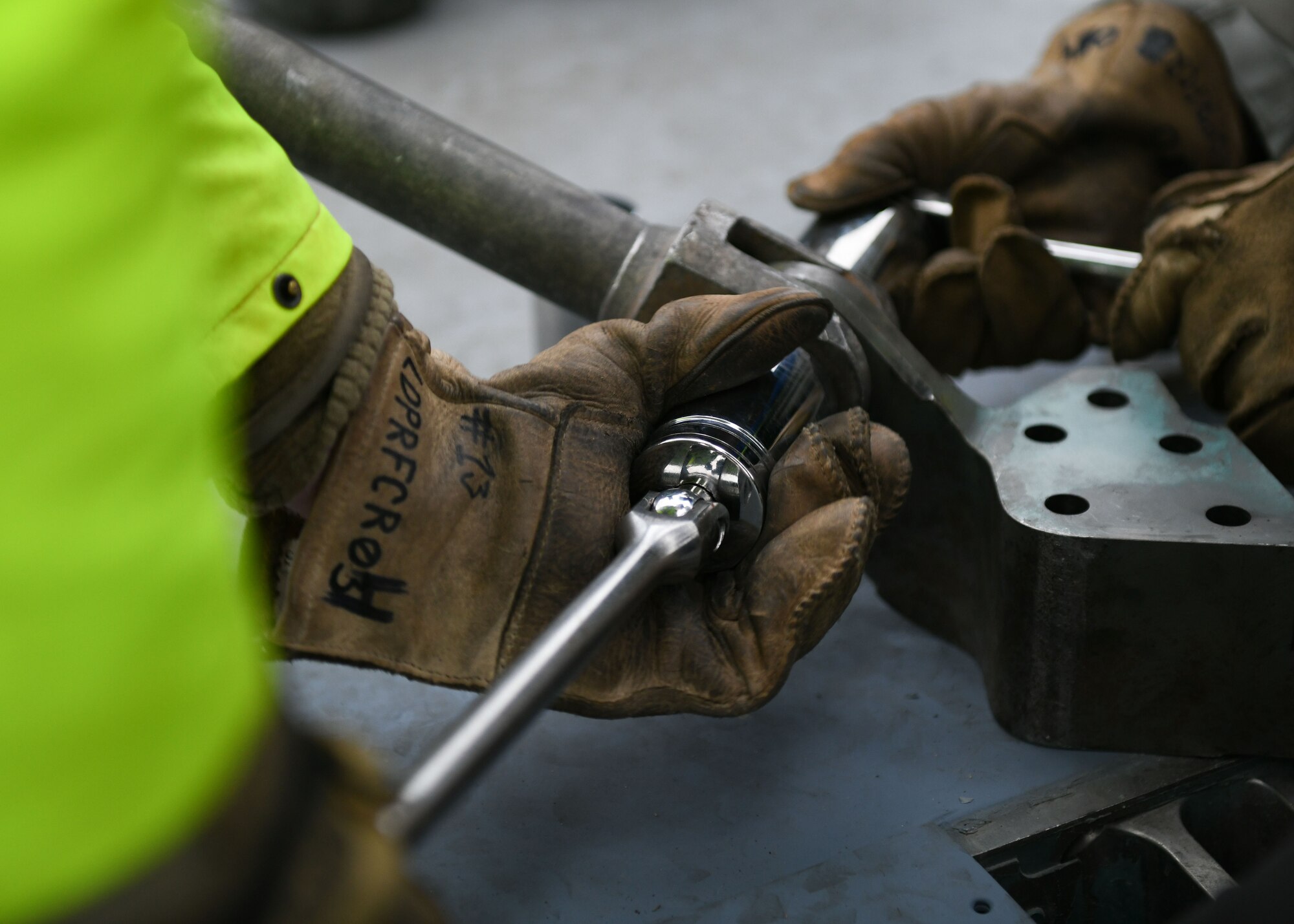 Airmen assigned to the 48th Equipment Maintenance Squadron repair and reclamation sections tighten a bolt to a wire cable sling during a simulated crash and recovery aircraft lift at Royal Air Force Lakenheath, England, Dec. 29, 2020. The purpose of the training was for members of the Crash Damaged Disabled Aircraft Recovery program to re-attain their certification and stay postured for the Liberty Wing if they are called upon. (U.S. Air Force photo by Senior Airman Madeline Herzog)
