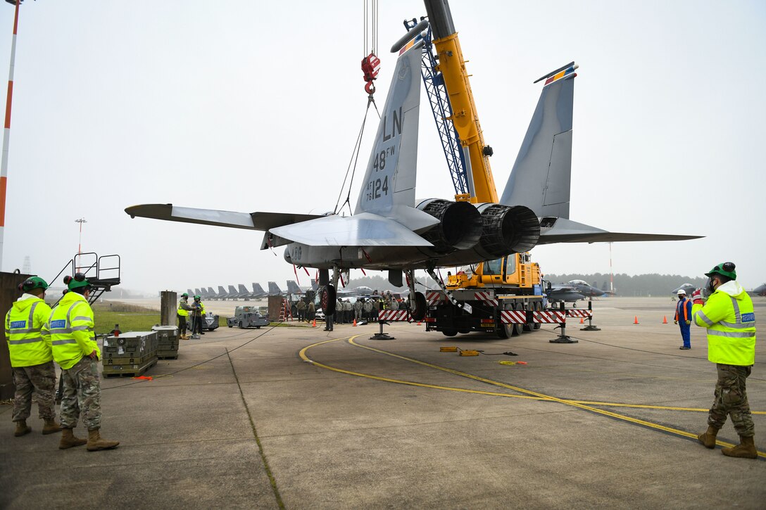 An F-15B is lifted by a crane during a simulated crash and recovery training at Royal Air Force Lakenheath, England, Dec. 29, 2020. This was the first crane lift at RAFL in 10 years and provided the recertification for the Crash Damaged Disabled Aircraft Recovery program to six team chiefs and eight CDDAR members to ensure the wing is ready at a moment’s notice. (U.S. Air Force photo by Senior Airman Madeline Herzog)