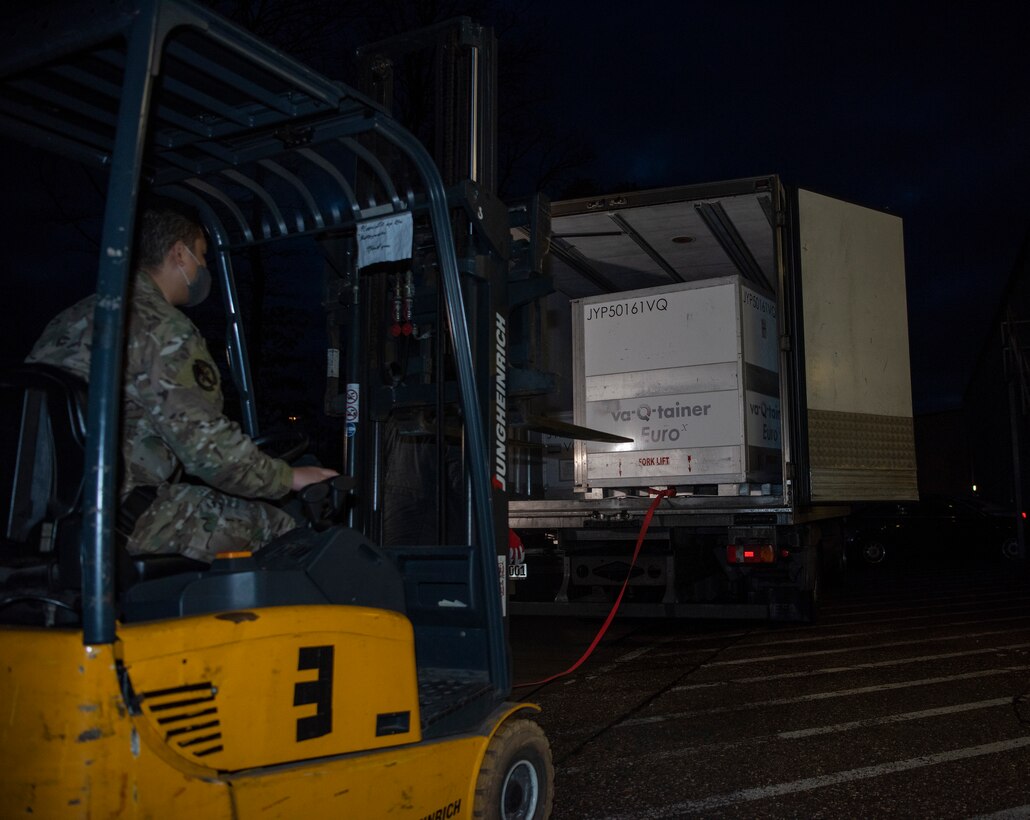 Airmen receive and offload an initial shipment of COVID-19 vaccines at Ramstein Air Base, Germany, Dec. 30, 2020.