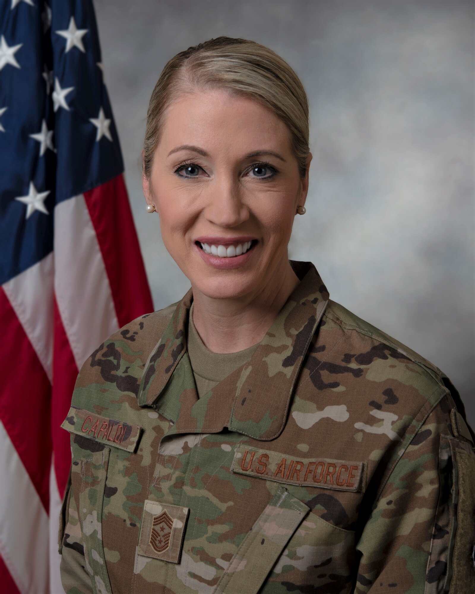 an airman poses in front of american flag