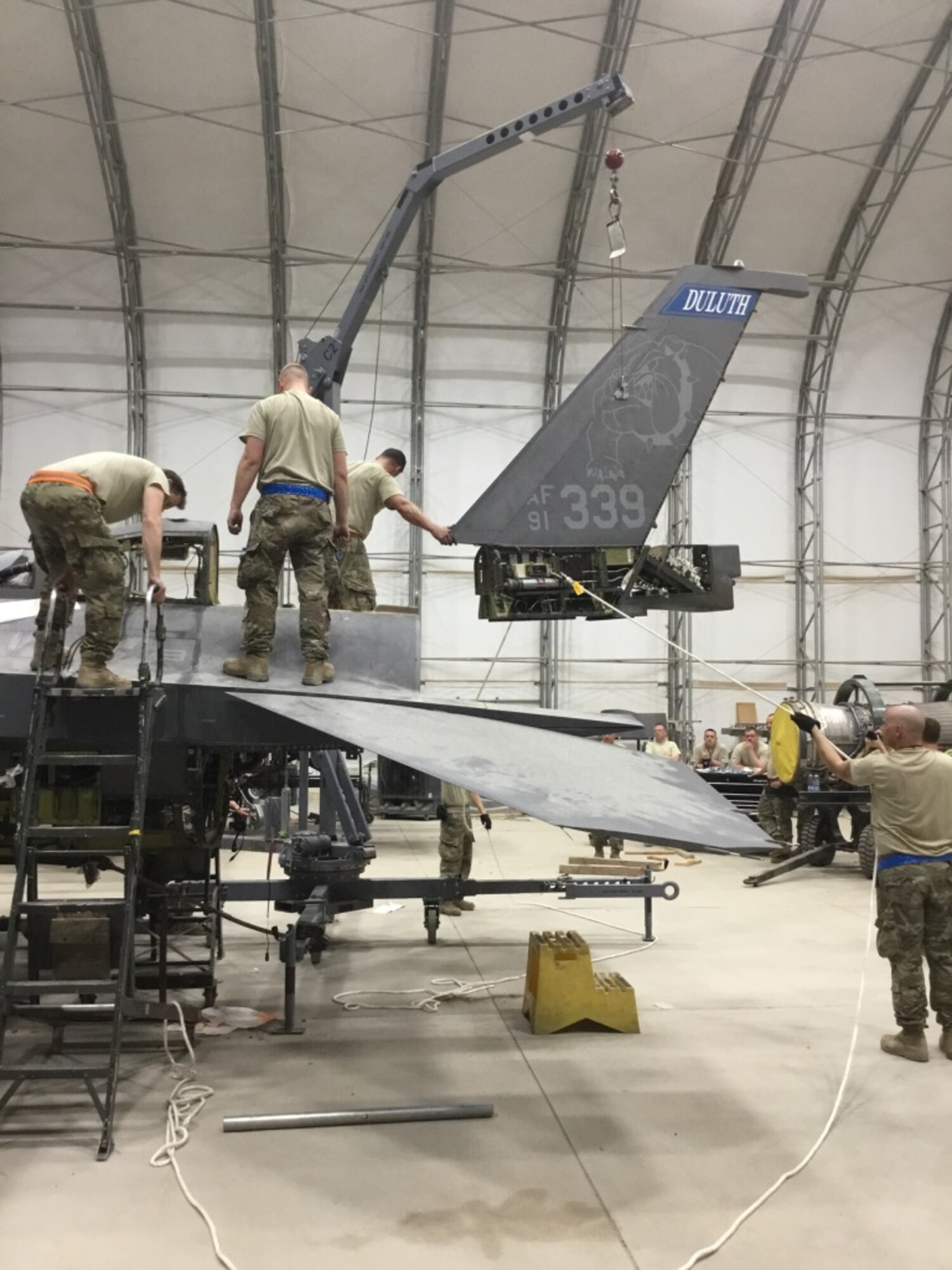 Aircraft maintenance personnel perform maintenance on battle damaged F-16s after a storm that caused 91-mile per hour winds to collapse sunshades at the 407th Air Expeditionary Group in 2018.