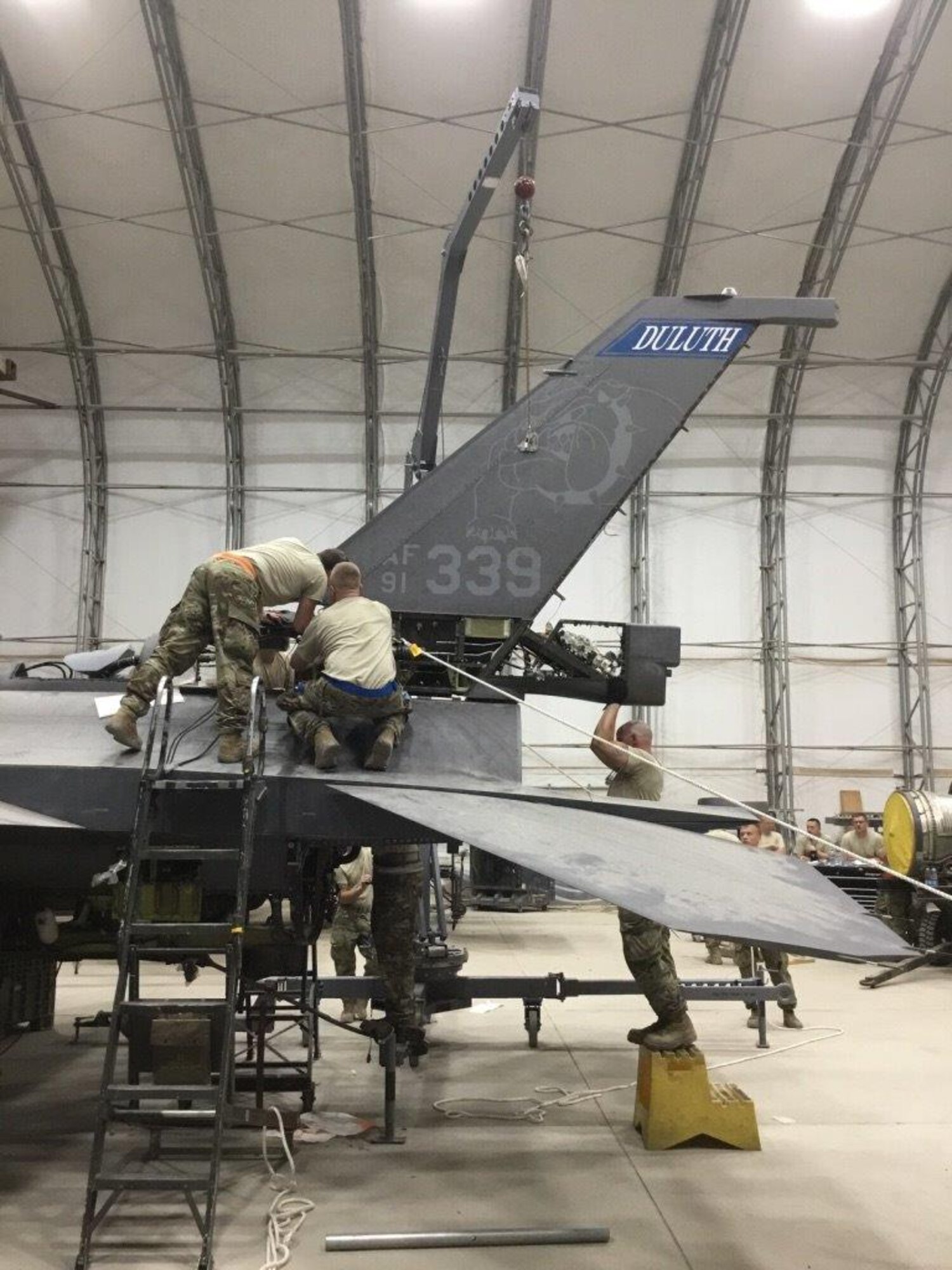 Aircraft maintenance personnel perform maintenance on battle damaged F-16s after a storm that caused 91-mile per hour winds to collapse sunshades at the 407th Air Expeditionary Group in 2018.