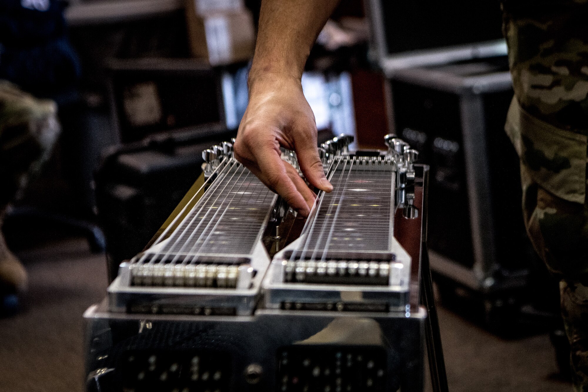 man strums steel guitar