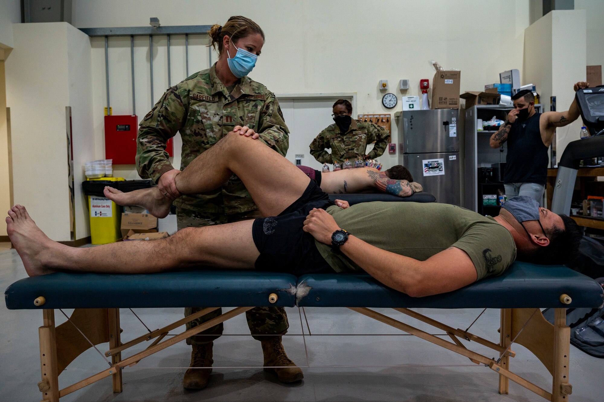 U.S. Air Force Capt. Kassia Garfield, 380th Expeditionary Medical Group (EMDG) physical therapist, performs stretches on Maj. Bryant Hankins, 380th Expeditionary Civil Engineer Squadron (ECES) explosive ordnance disposal technician, during an in-house physical therapy session at Al Dhafra Air Base (ADAB), United Arab Emirates, Dec. 15, 2020.