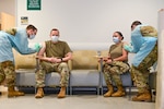 U.S. Army Health Clinic Stuttgart conducted its first inoculations of healthcare workers and first responders with the Moderna COVID-19 vaccine at Patch Barracks, Stuttgart, Germany, Dec. 31, 2020. U.S. Army Lt. Col. Adam Cronkhite (seated left), Director of Emergency Services, and U.S. Army Lt. Col. Maria Bruton (seated right), commander of USAHC Stuttgart, simultaneously were the first to receive the COVID-19 vaccine in the Stuttgart military community.