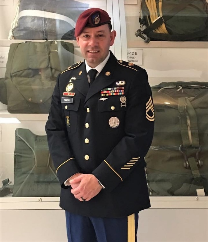 The late Sgt. 1st Class James Smith posed for a photograph in his Army Service Uniform in front of a paratrooper equipment display at Fort Lee, Virginia in 2015. Sarah Smith took part in the 94th Training Force Sustainment Headquarters and Headquarters Company virtual suicide prevention training. She shared her story about the loss of her husband due to suicide. The 94th TD-FS HHC suicide prevention training was conducted on October 24, 2020. (Photo courtesy of Sarah Smith, widow of service member)